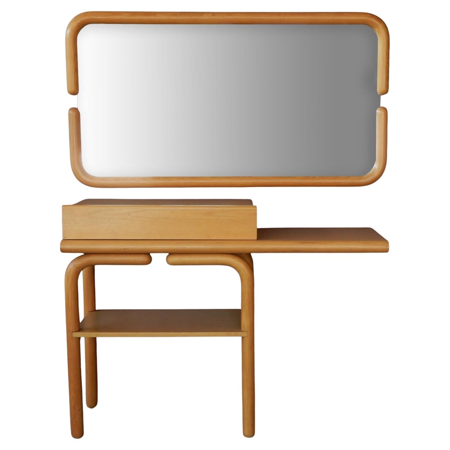 Unique, petite single drawer vanity and mirror after the design of Alvar Aalto for Artek. 
It's simplistic design is stunning.
Circa 1960's, this piece is constructed using natural Birch
veneers with solid dowl legs and mirror surround. 
We could