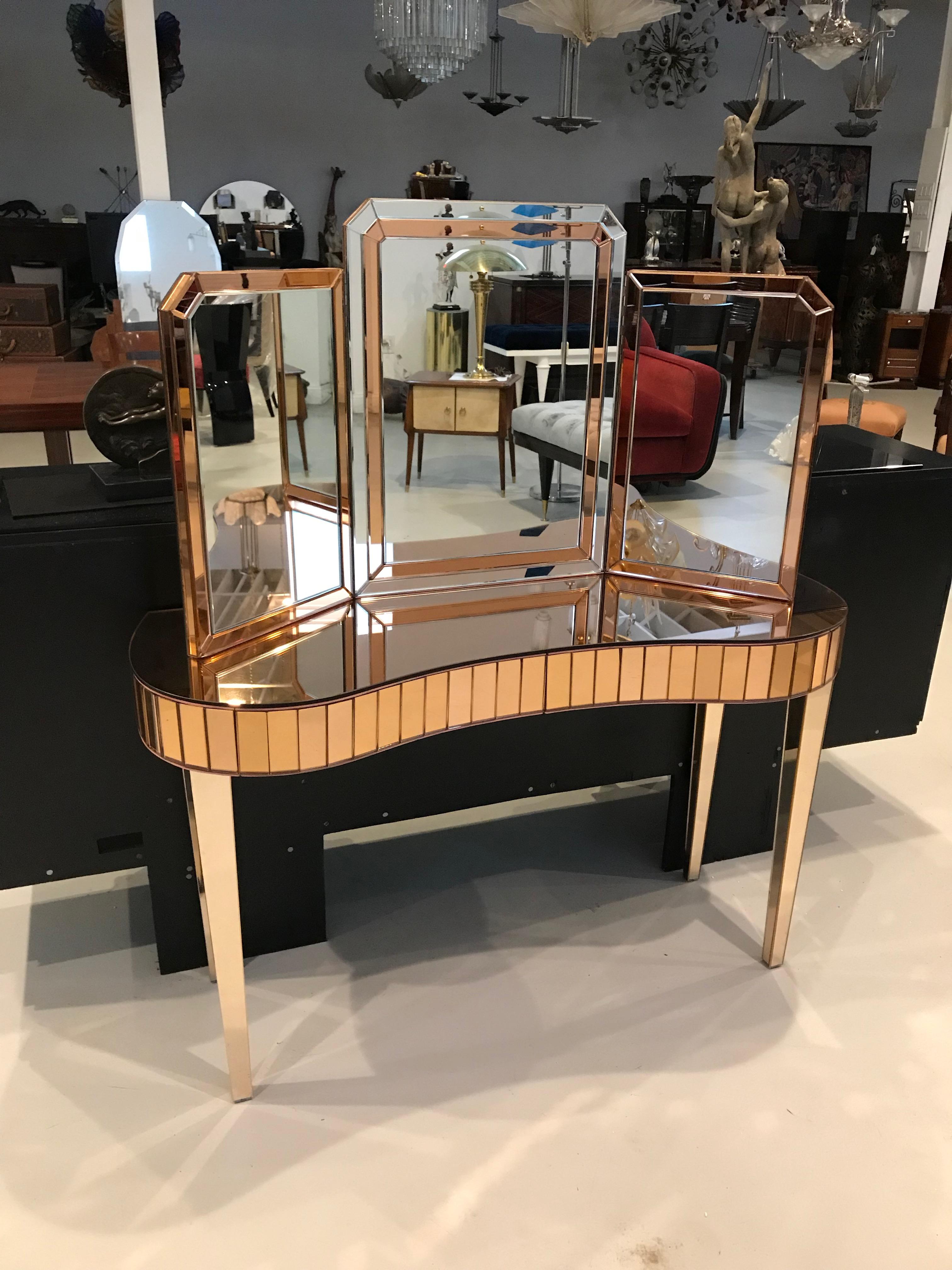 Mid-Century Modern mirrored vanity with matching mirror. The mirror can either be hung on the wall or can sit on the vanity. The vanity is all mirrored with an Art Deco motif. Having two draws for plenty of storage.

Vanity dimensions:
H 28