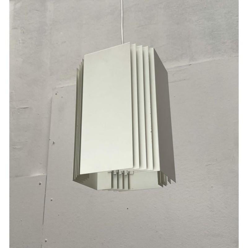 Lampe suspendue minimaliste du fabricant finlandais Orno, basée sur un design de Heikki Turunen des années 1960.

Le corps de la lampe a une forme cubique. Il se compose de quatre éléments métalliques biseautés reliés par des barres. La