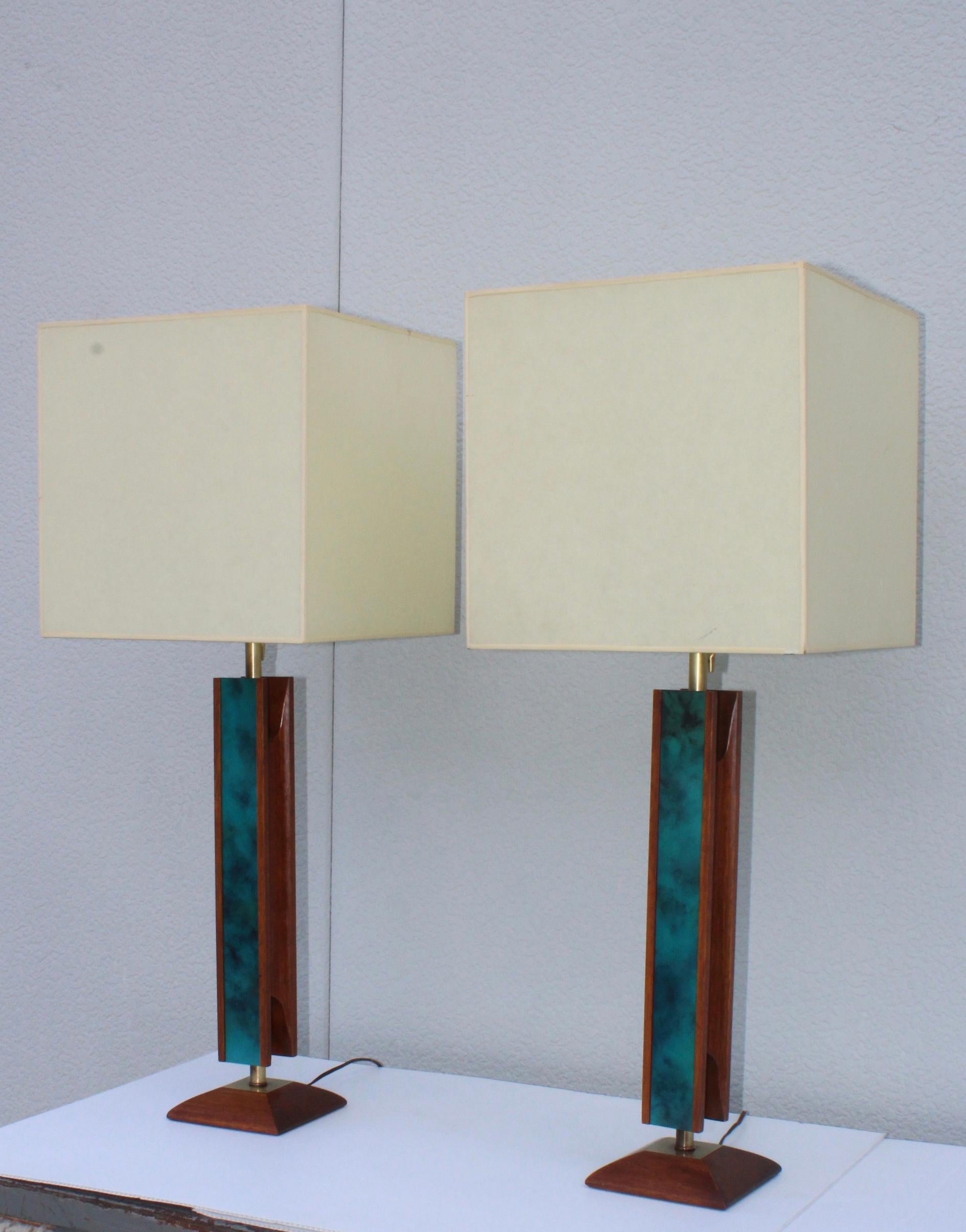1960s Mid-Century Modern walnut and brass table lamps by Modeline. With enamel detail.

Measures: Height to light socket 27''.

Shades for photography only.