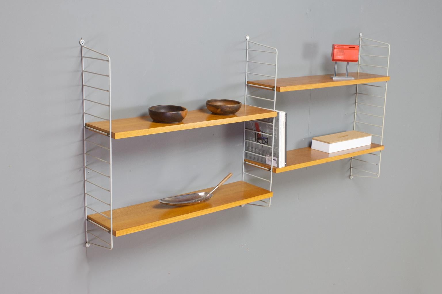 Original vintage adjustable shelving unit by String Sweden. This modulair wall system consist of four birch shelves and three grey coated (metal wire) brackets. The shelves can be placed in any given height. The unit is in great vintage condition,