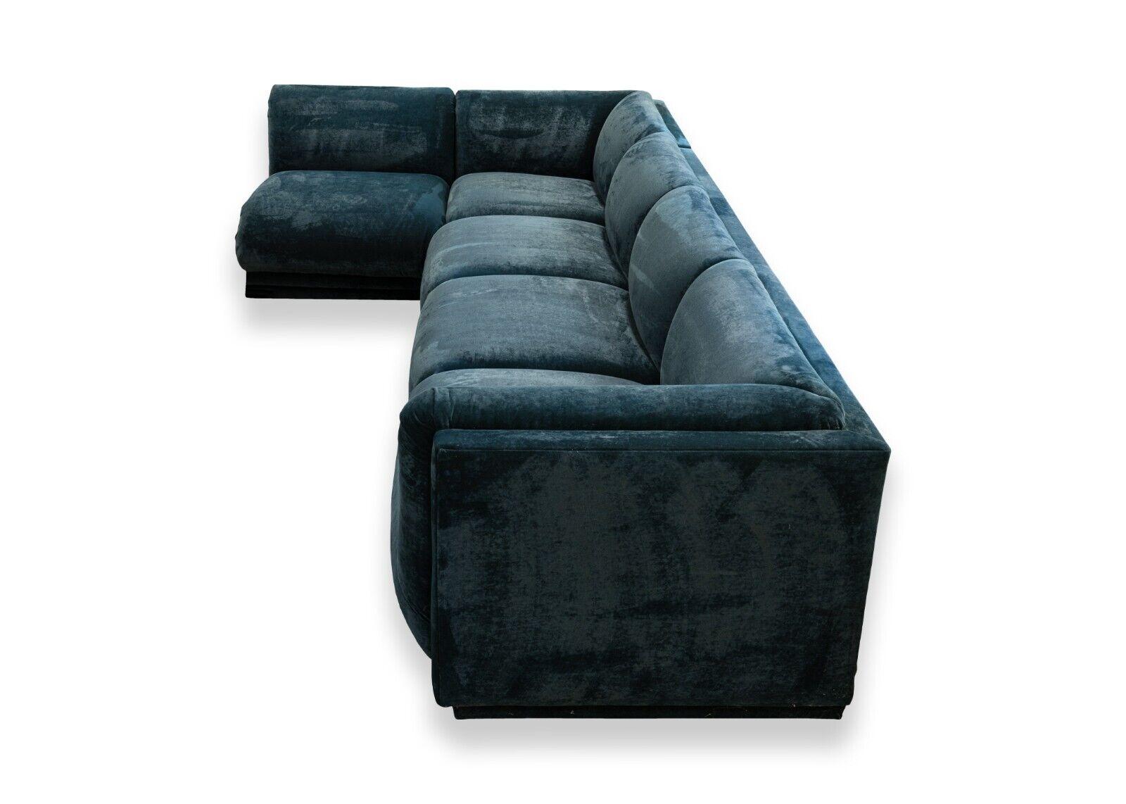 A modular blue green crushed velvet sofa sectional. This stunning sectional is covered in a very unique velvet color reminiscent of blues and greens. The color shifts slightly with the lighting its placed in. This sectional consists of three pieces: