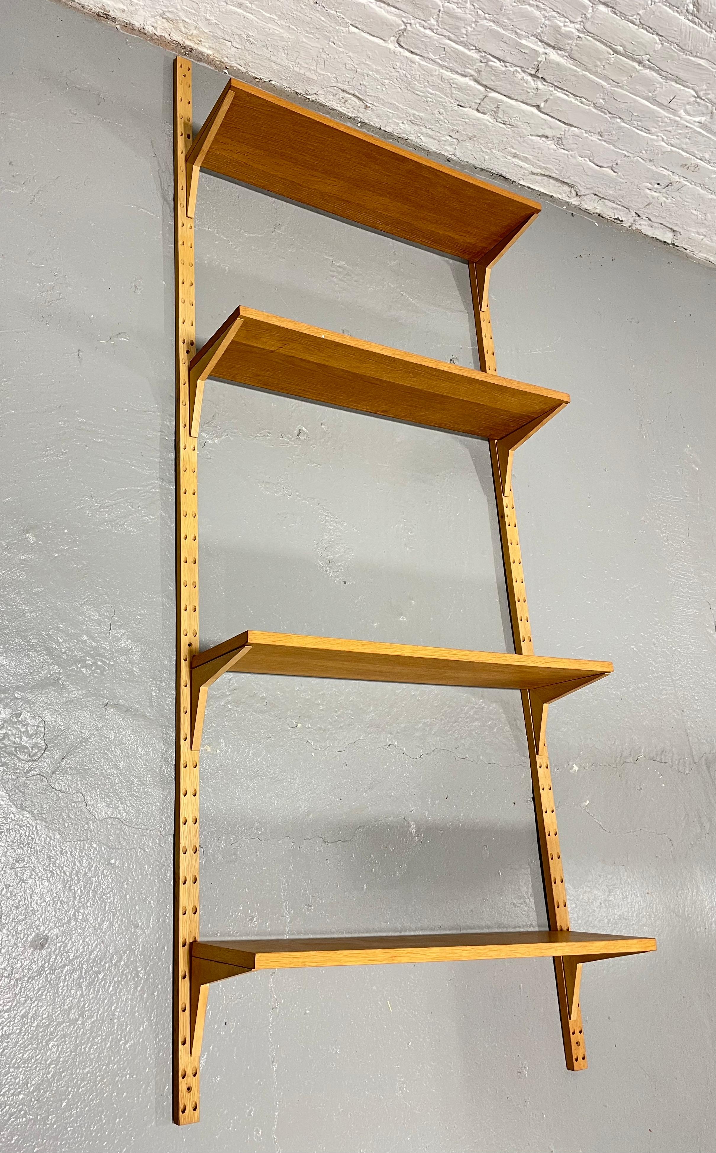 Orignial Danish Modern Mid Century Cado Wall Shelving System in hard to find light oak, c. 1960's. Great single bay unit consisting of four shelves that can be arranged anywhere on the rails. Each shelf is stamped 