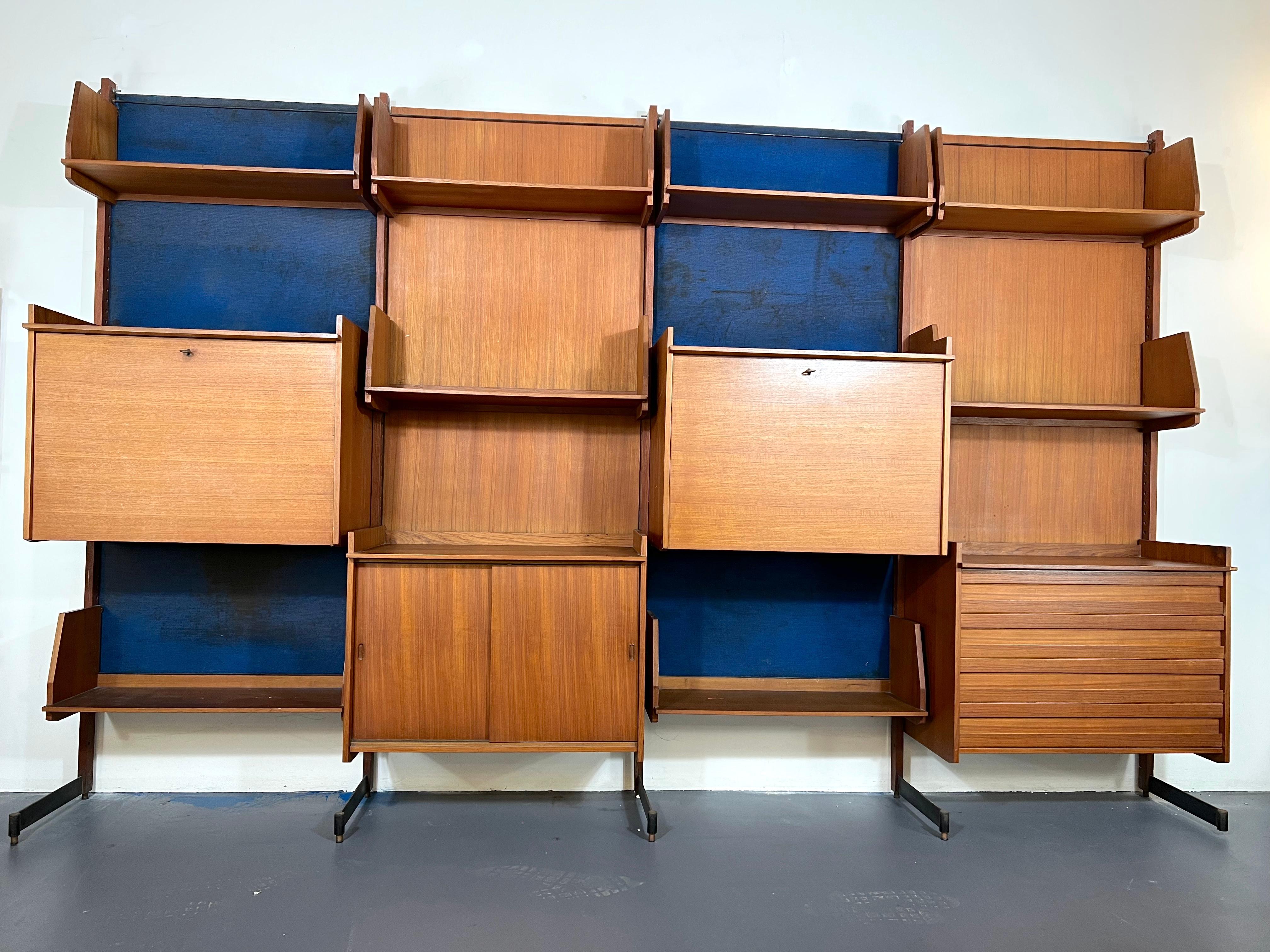 Good vintage condition with trace of age and use for this wall unit made from wood and metal with brass details. The blue velvet background is in poor condition. Produced in Italy during the 1950s.