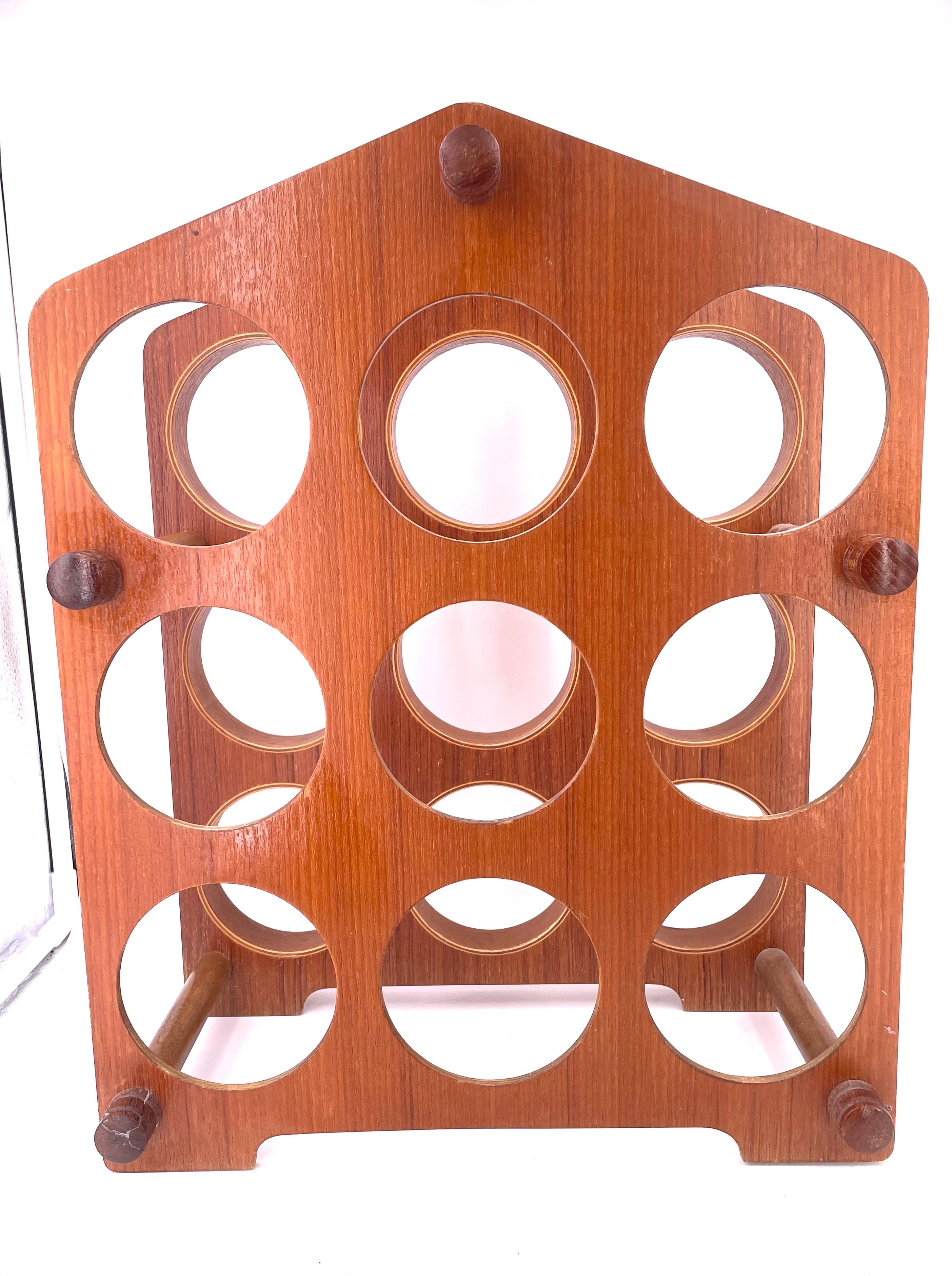 A very cool design and rare vintage molded teak, 9 bottle capacity wine rack, retains old made in Japan label.