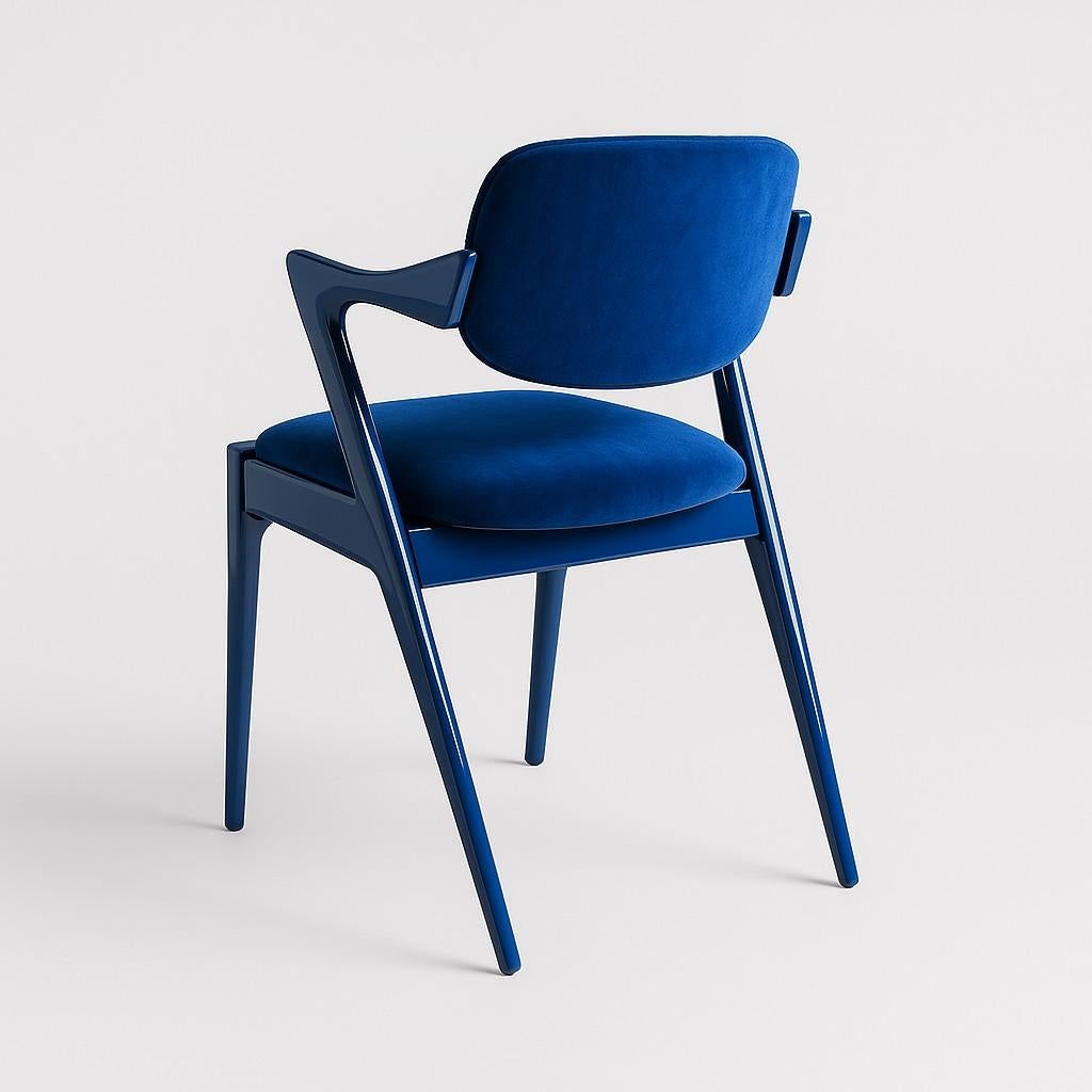 This dining chair boasts a distinctive, ergonomically designed form. Its armrests feature a subtle, natural dip, while the curved back provides excellent support. The chair's legs and frame are crafted from solid ash, beautifully complemented by the