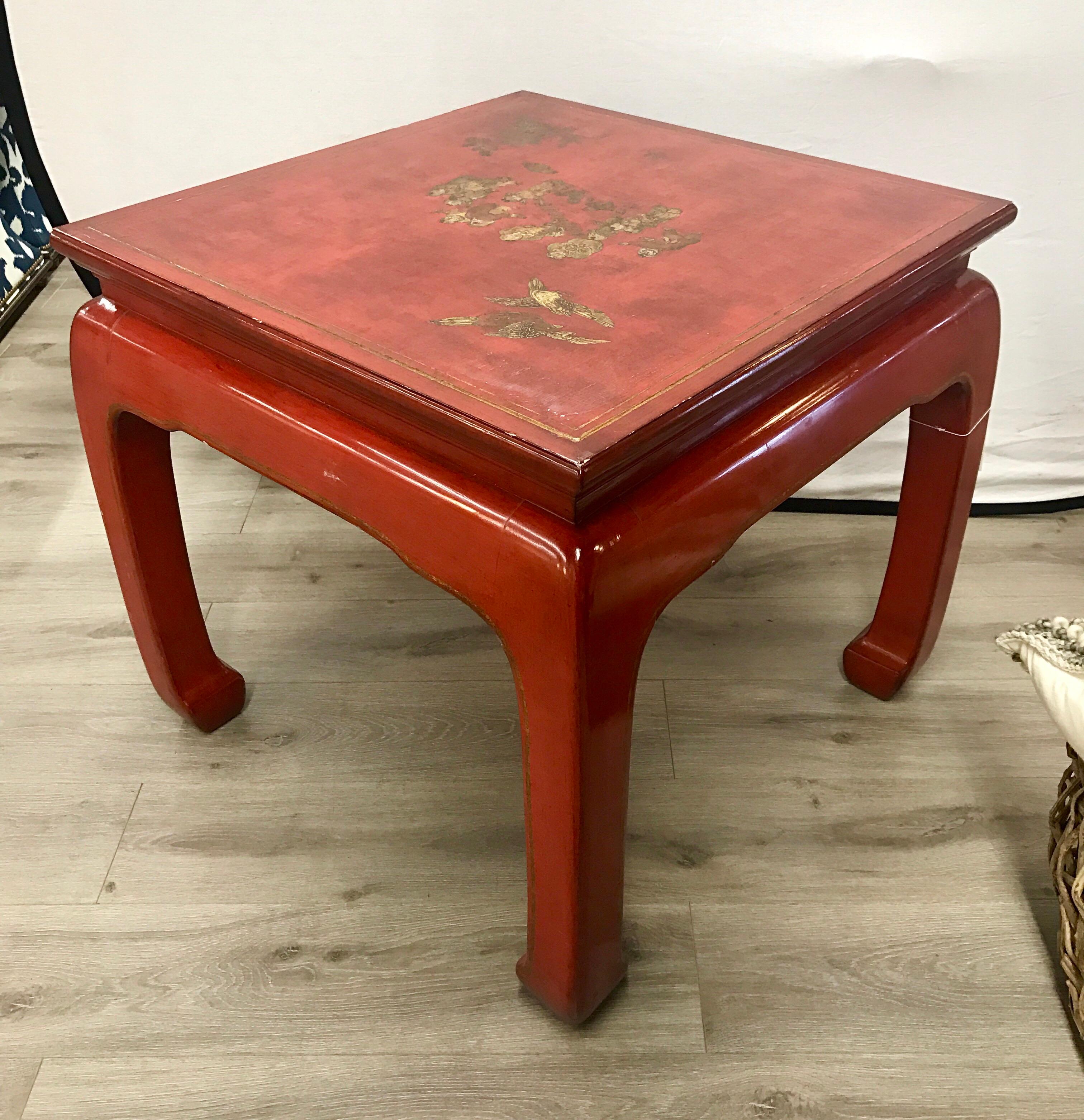 Elegant red lacquer end table or occasional table with hand paintings. In the style of James Mont.