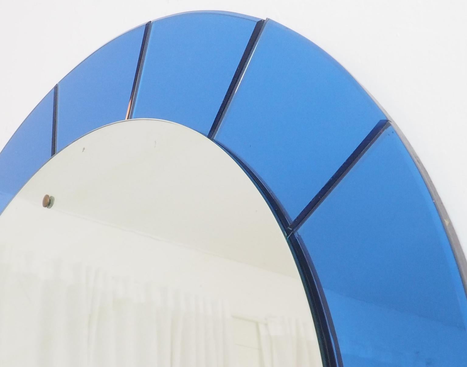 Original vintage very large 110 cm! 43.30 inches
Round wall mirror in a splendid blue color mirrored glass frame with brass buttons for fixing the central mirror, wood back.
  