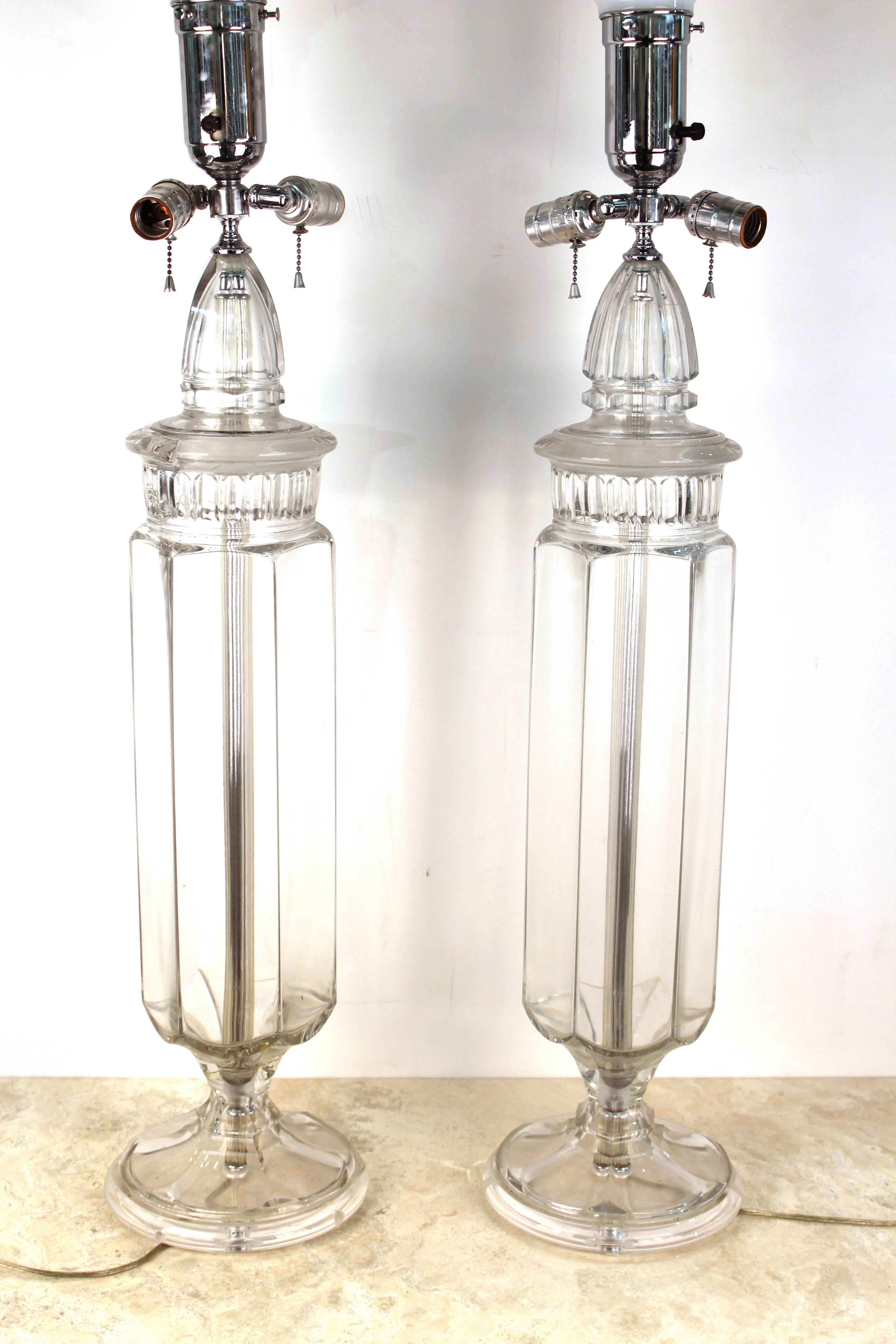 A pair of monumental size Mid-Century Modern table lamps in form of clear glass containers. The pair is in great vintage condition with age appropriate use.