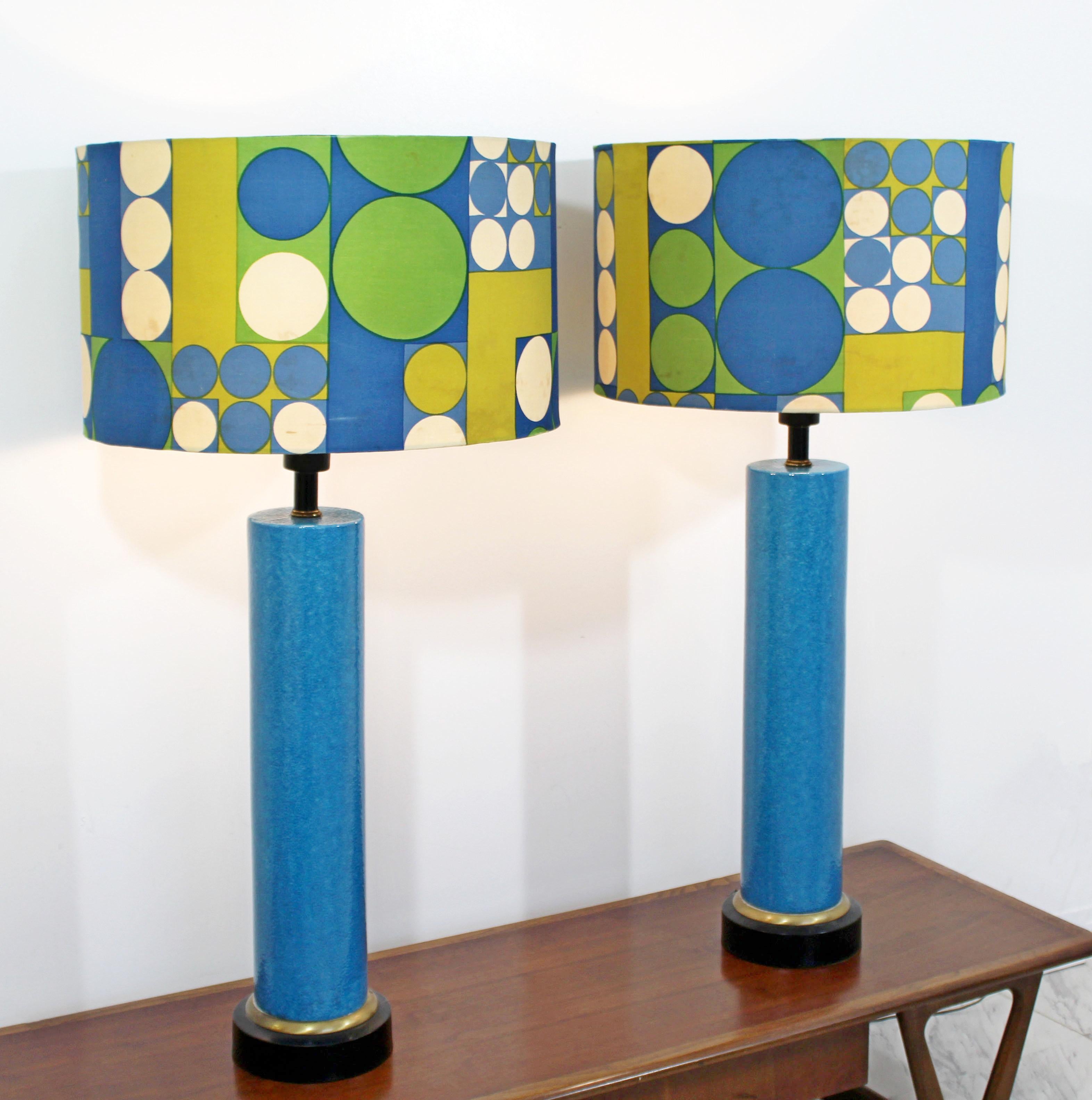 For your consideration is a massive pair of blue ceramic table lamps, with their original and groovy shades and finials, circa the 1960s. The lamps are in excellent vintage condition, but the shades have some staining. The dimensions of the lamps