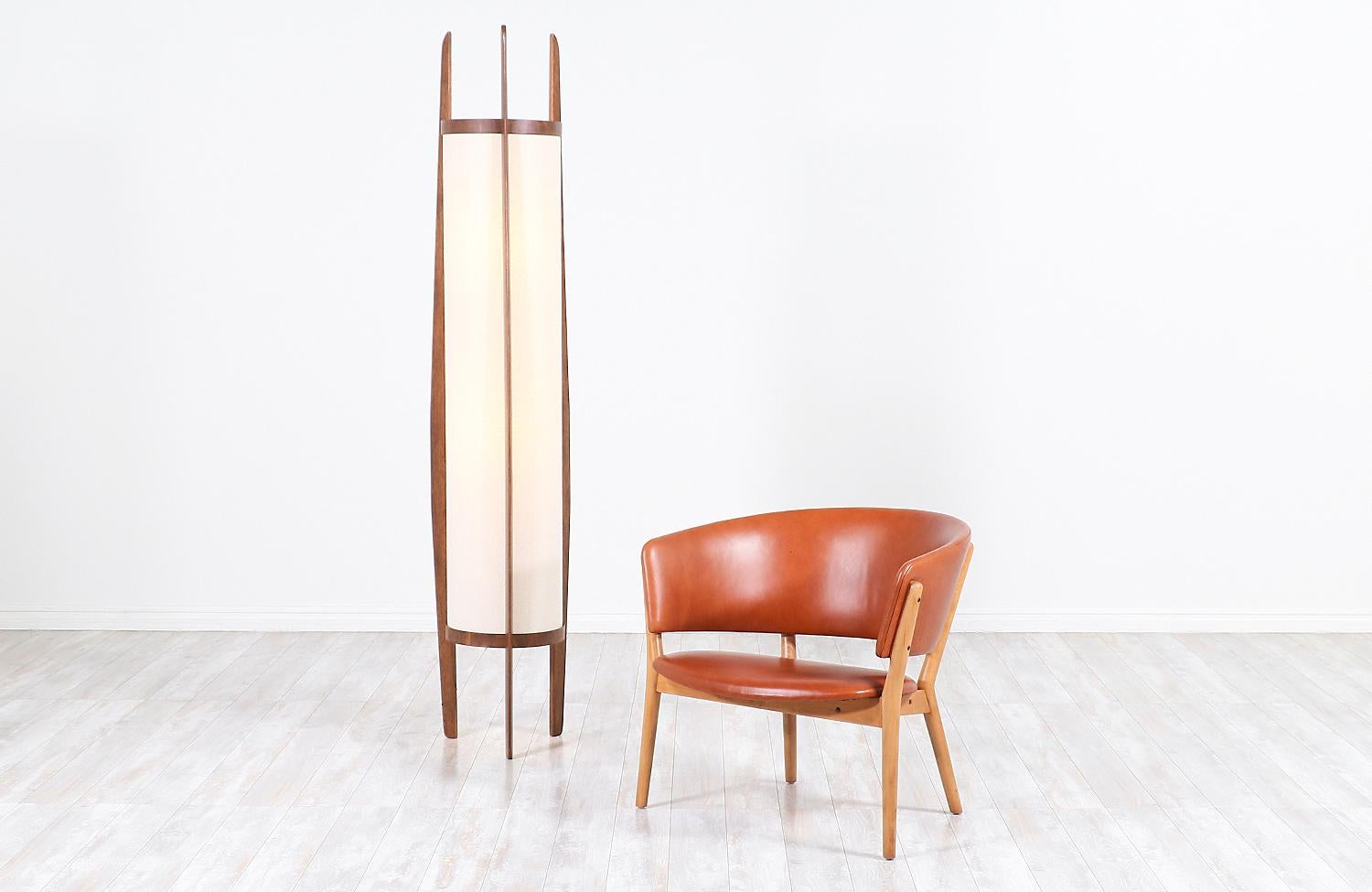 Dazzling vintage floor lamp designed and manufactured by Modeline of California, circa 1960s. This exceptional hand-sculpted floor lamp features a tall sculpted walnut wood body with three asymmetrical arms that go up the body frame holding the new