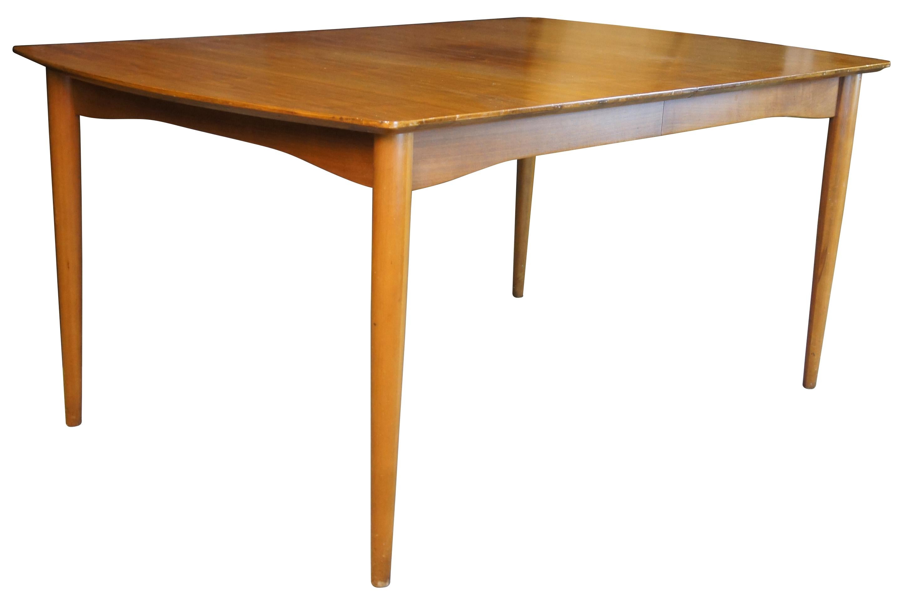 Mid-Century Modern Morganton walnut dining table featuring Danish styling with rectangular form, rounded ends, tapered legs and extra leaves.

Measures: 38