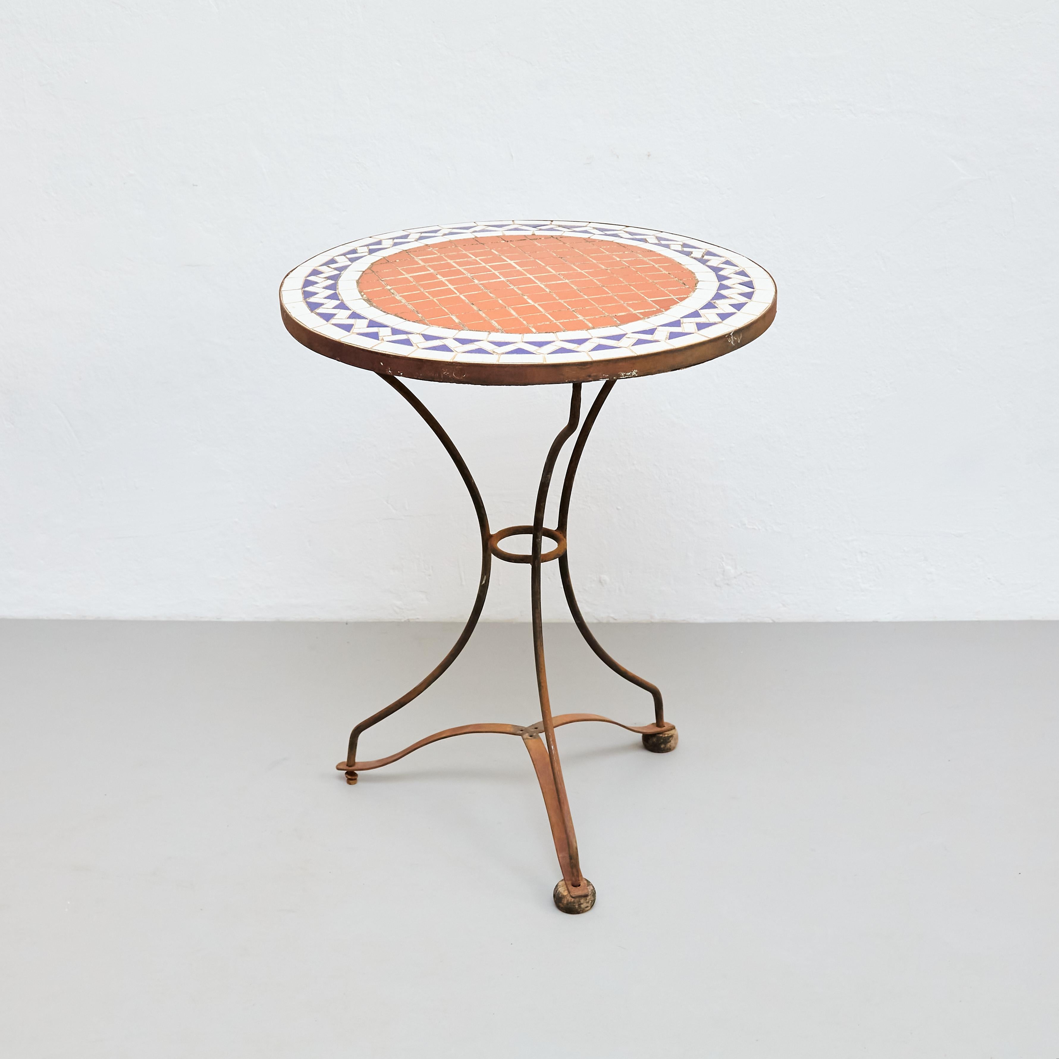 This Mid-Century Modern Mosaic Bistrot French Coffee Table is a stunning piece of furniture, exuding elegance and sophistication. Manufactured in France circa 1960, this table boasts a unique and eye-catching mosaic design that is sure to draw the