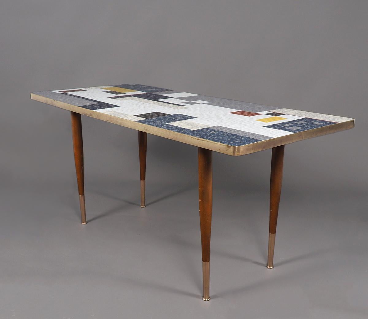 Vintage mosaic coffee table or side table produced by Ilse Möbel in the 1950s.

Model Paris.

Beautiful abstract (reminiscent of Mondrian) inlaid tabletop with different colors of grey, white, blue, yellow and red.

The top is framed with a