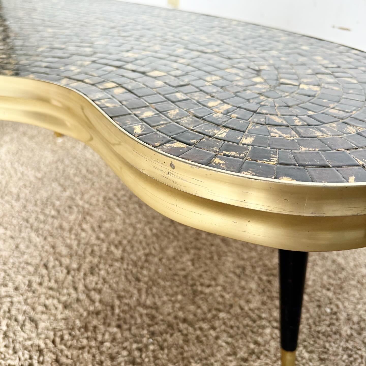 Delve into the elegance of the Mid Century Modern era with this unique Kidney Coffee Table, featuring a stunning mosaic top with black and goldish-brown tiles. Its distinctive kidney shape and three-legged design, accented with black paint and gold