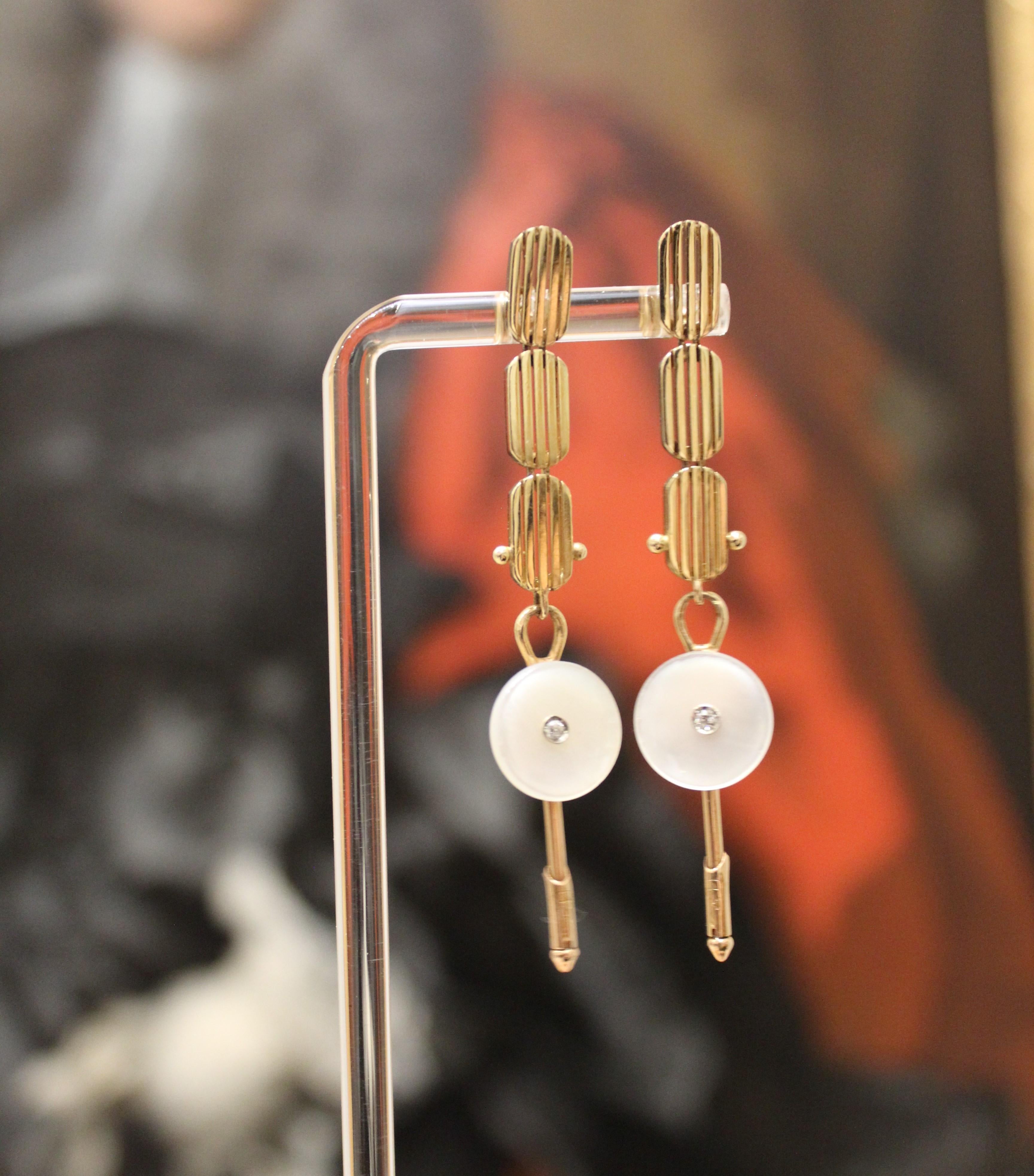 These contemporary, reconstructed Mid-century Modern gold and mother of pearl earrings are from a vintage jewelry collection in Manhattan's diamond district. There are diamonds at the center of the mother of pearl. 

Once they traveled to La Jolla