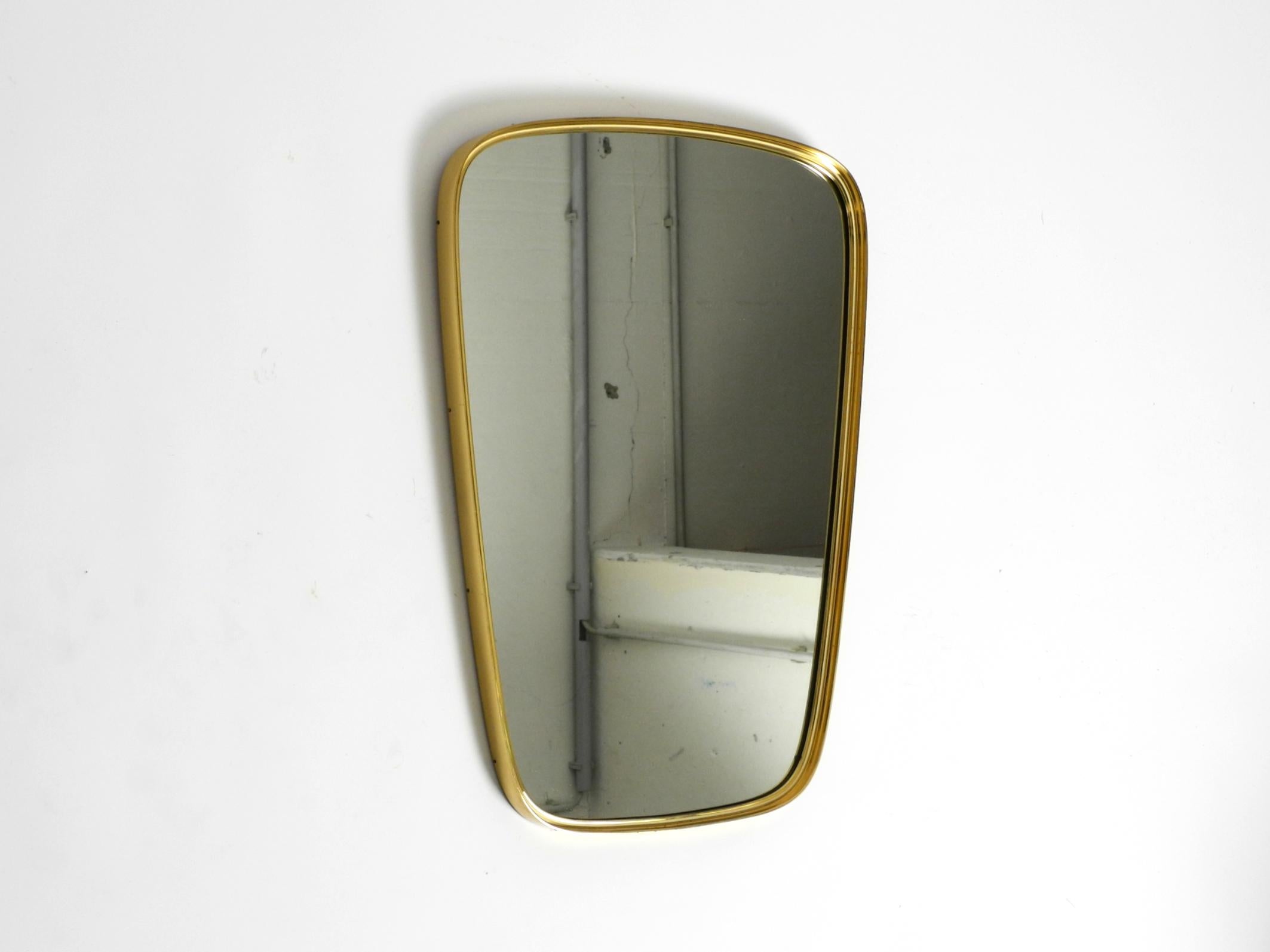 Magnifique miroir mural original du milieu du siècle avec un cadre en laiton lourd.
Design/One minimaliste typique des années 1950. Fabrication de très haute qualité et poids élevé.
Le fabricant est Münchener Zierspiegel. Fabriqué en Allemagne.
En