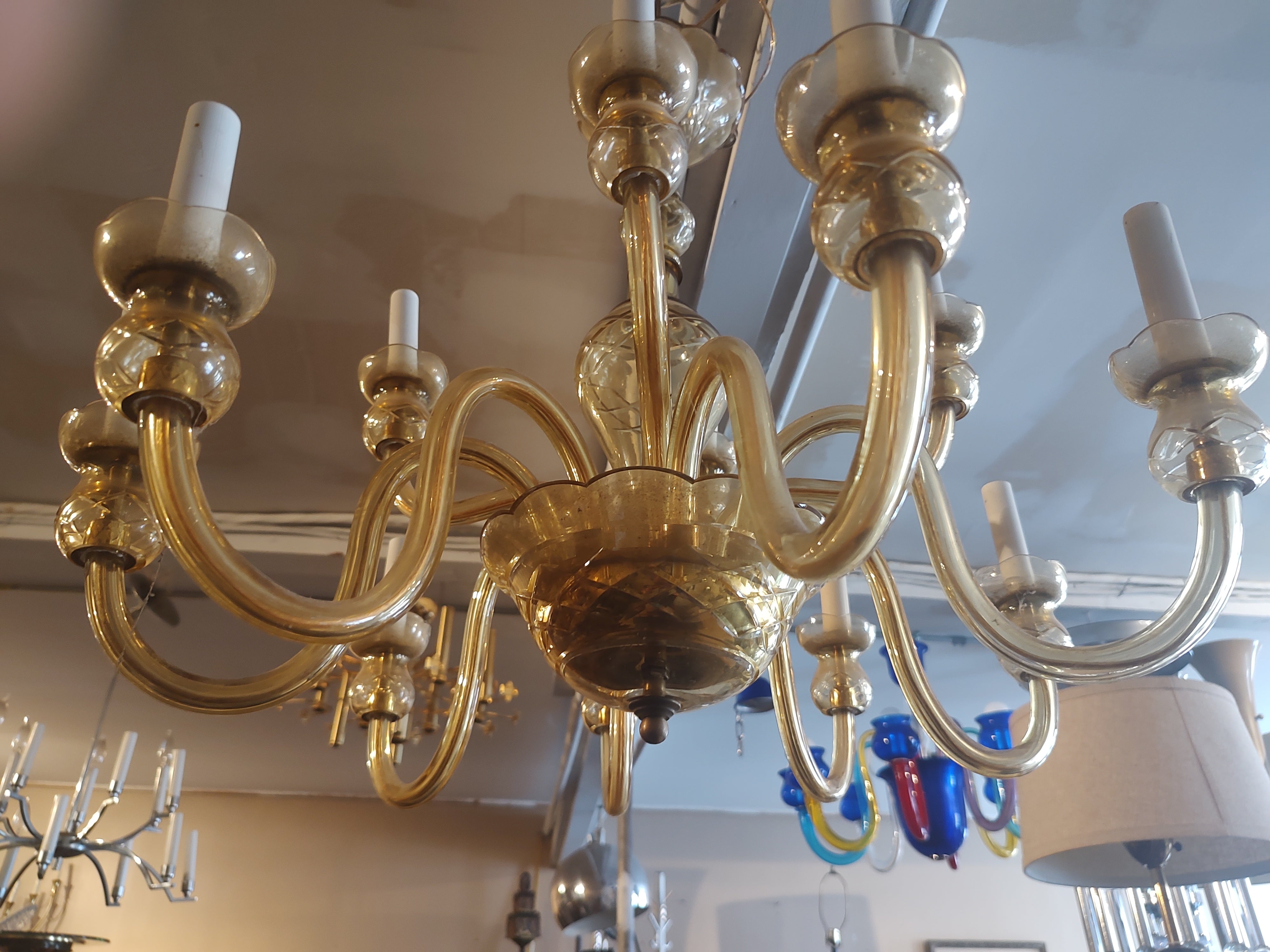 Fabulosa araña artesanal de Murano de 12 luces de color ámbar atribuida a Gino Vistosi. Dos niveles de iluminación con 8 en la parte inferior y 4 en la superior. En excelente estado vintage, todos los manguitos de las tomas son nuevos, el cableado