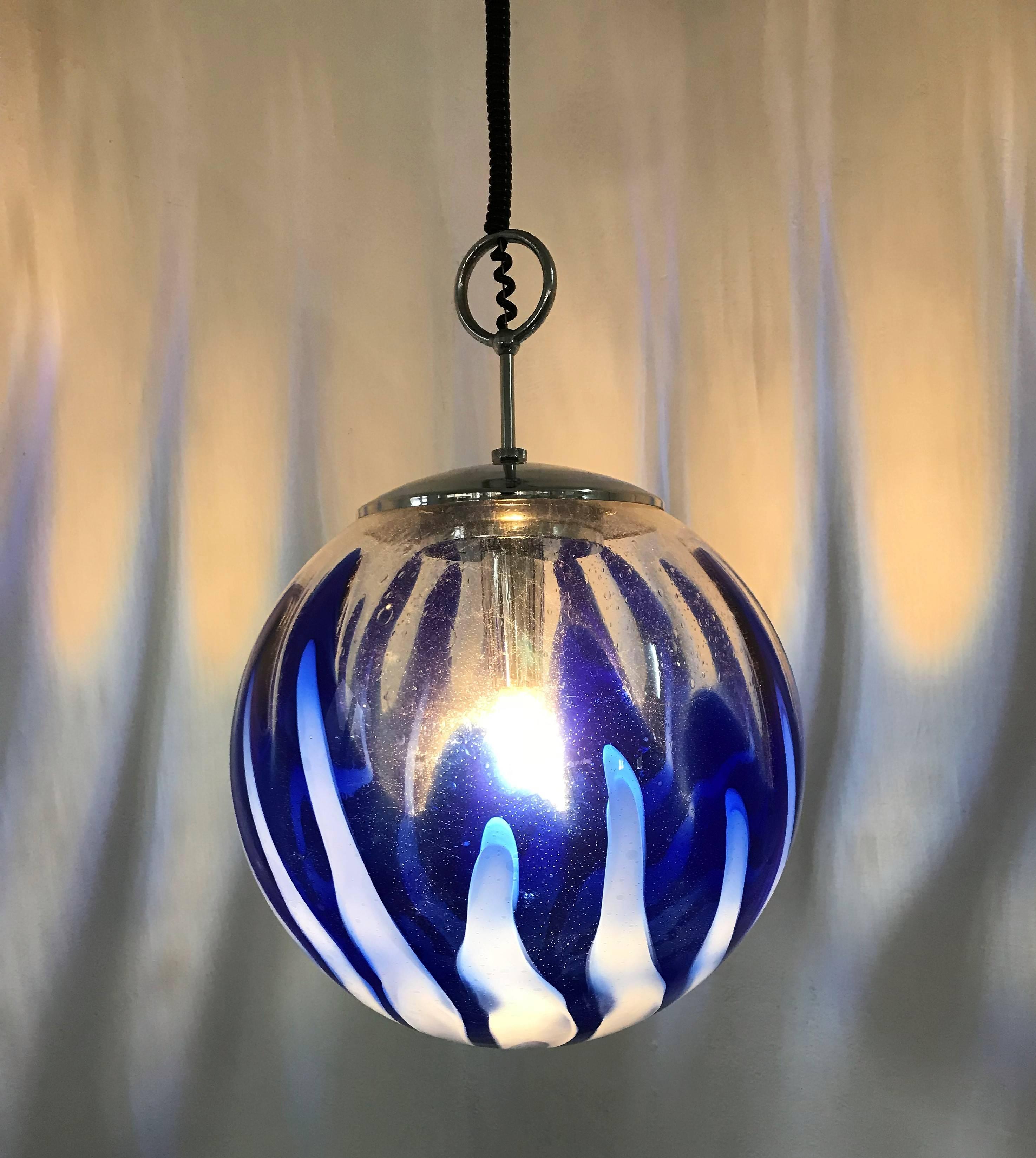 Beautiful and large pendant light in blue, white and clear handblown Murano glass, attributed to Mazzega, circa 1970
Diameter is 40 cm.
     