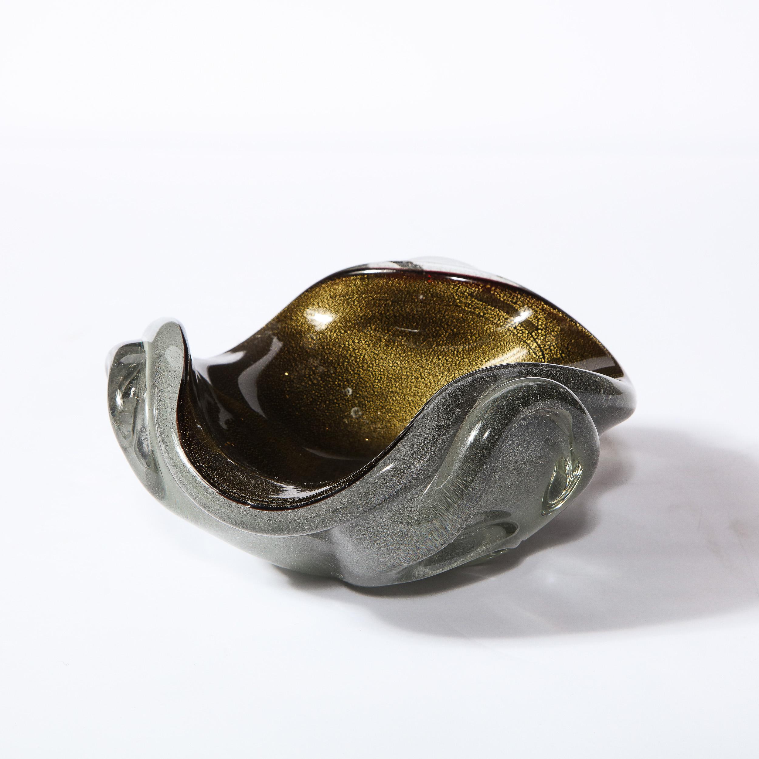 This beautiful Mid-Century Modern bowl was realized in Murano, Italy- the island off the coast of Venice renowned for centuries for its superlative glass production. It features a circular form with raised sides and scalloped detailing. The bowl has