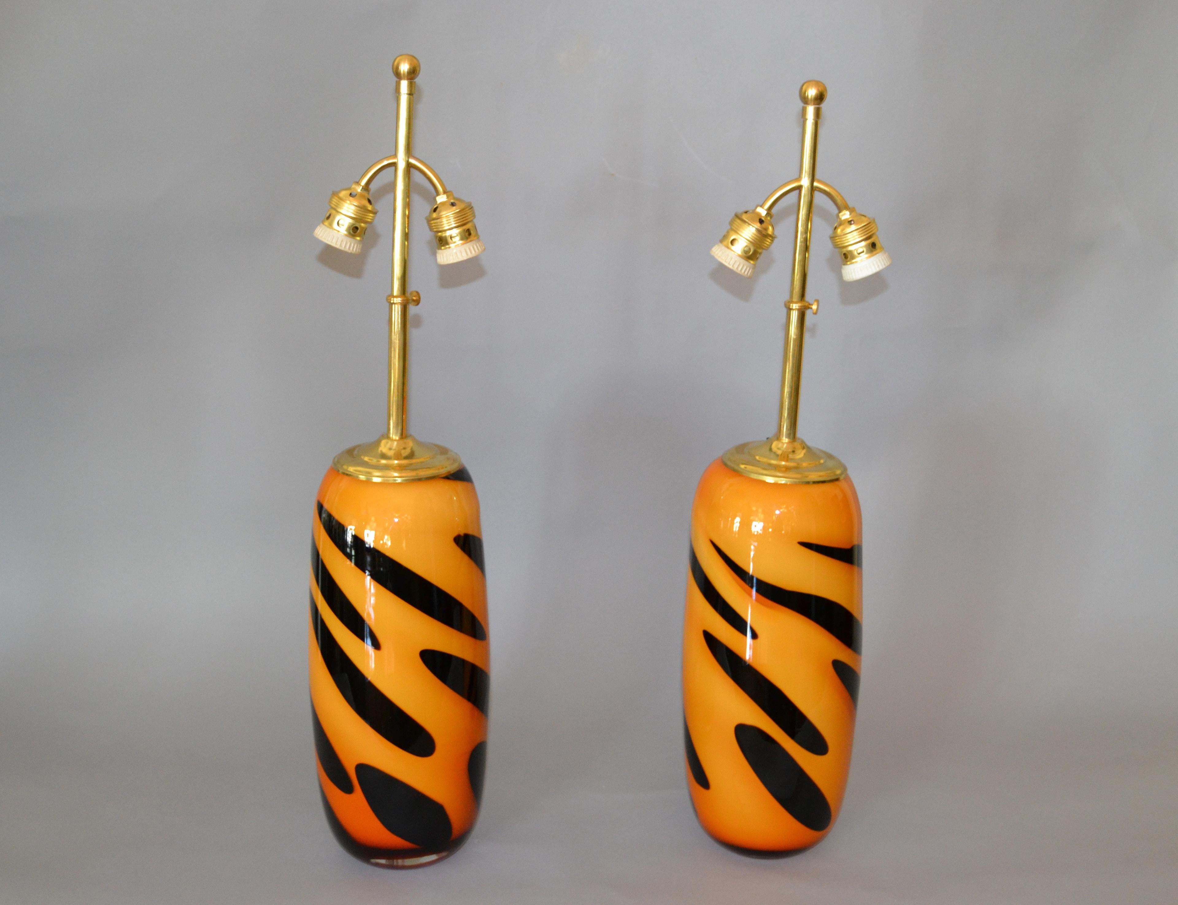 A pair of Mid-Century Modern heavy Murano glass and brass table lamps with tiger stripe motif.
Deep orange and black in Murano glass.
In perfect working condition and each lamp uses 2 max. 40 watts light bulbs.
The height of the lamp shade is