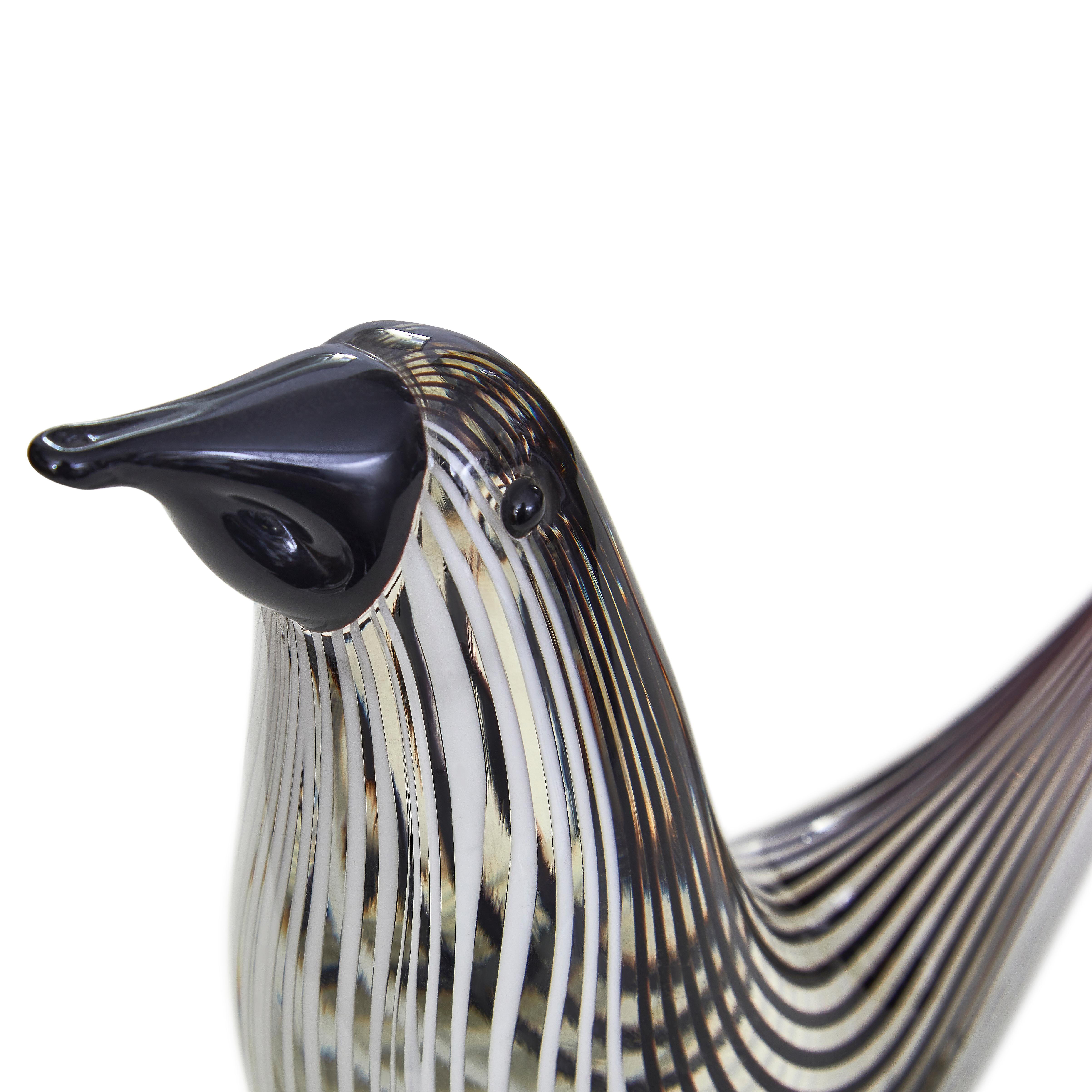 Elegant simple glass bird using the Murano Filigrana technique. The back of the bird has black glass rods and the front white, the beak and eyes were applied later in black glass.
Cloured crystal rods are prepared beforehand which are heated in the