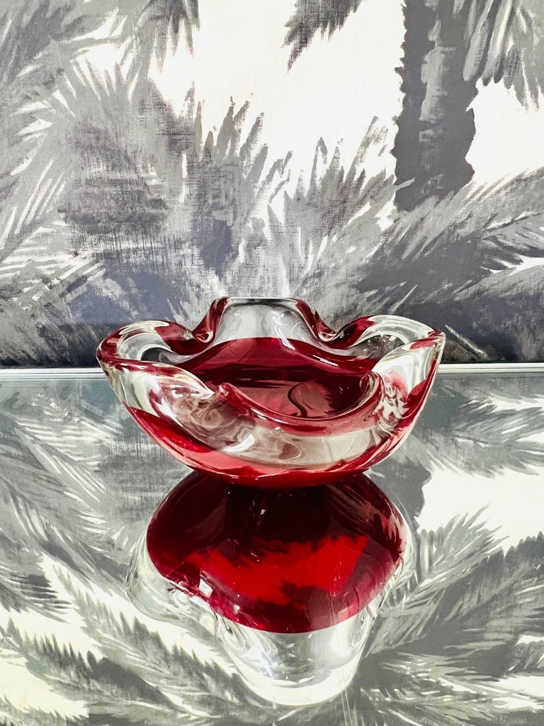 Vintage Italian decorative bowl or ashtray in ruby red and clear glass featuring Sommerso technique, whereby the colored glass is submerged or cased within clear glass.  The handblown bowl features a butterfly rim with pinched centers.  Makes a