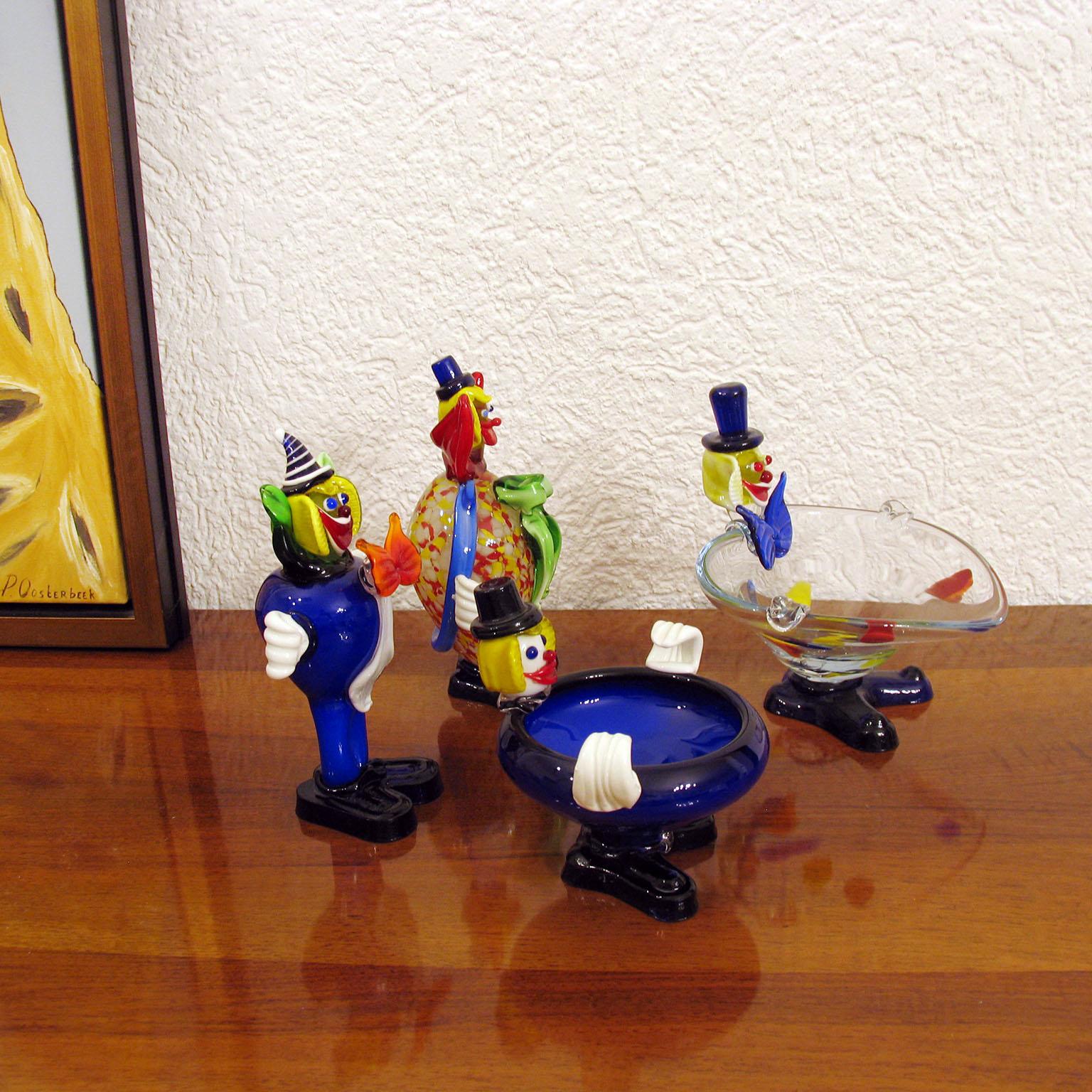 Fröhliche Clowns aus Muranoglas:: bunte Glaskörper:: lustige Gesichter:: zwei davon als Videopoche geformt:: was sie auch nützlich macht. Sie bringen einen Farbtupfer in jede Ecke Ihres Hauses!
Ausgezeichneter Zustand. 
Abmessungen: 
Großer dicker
