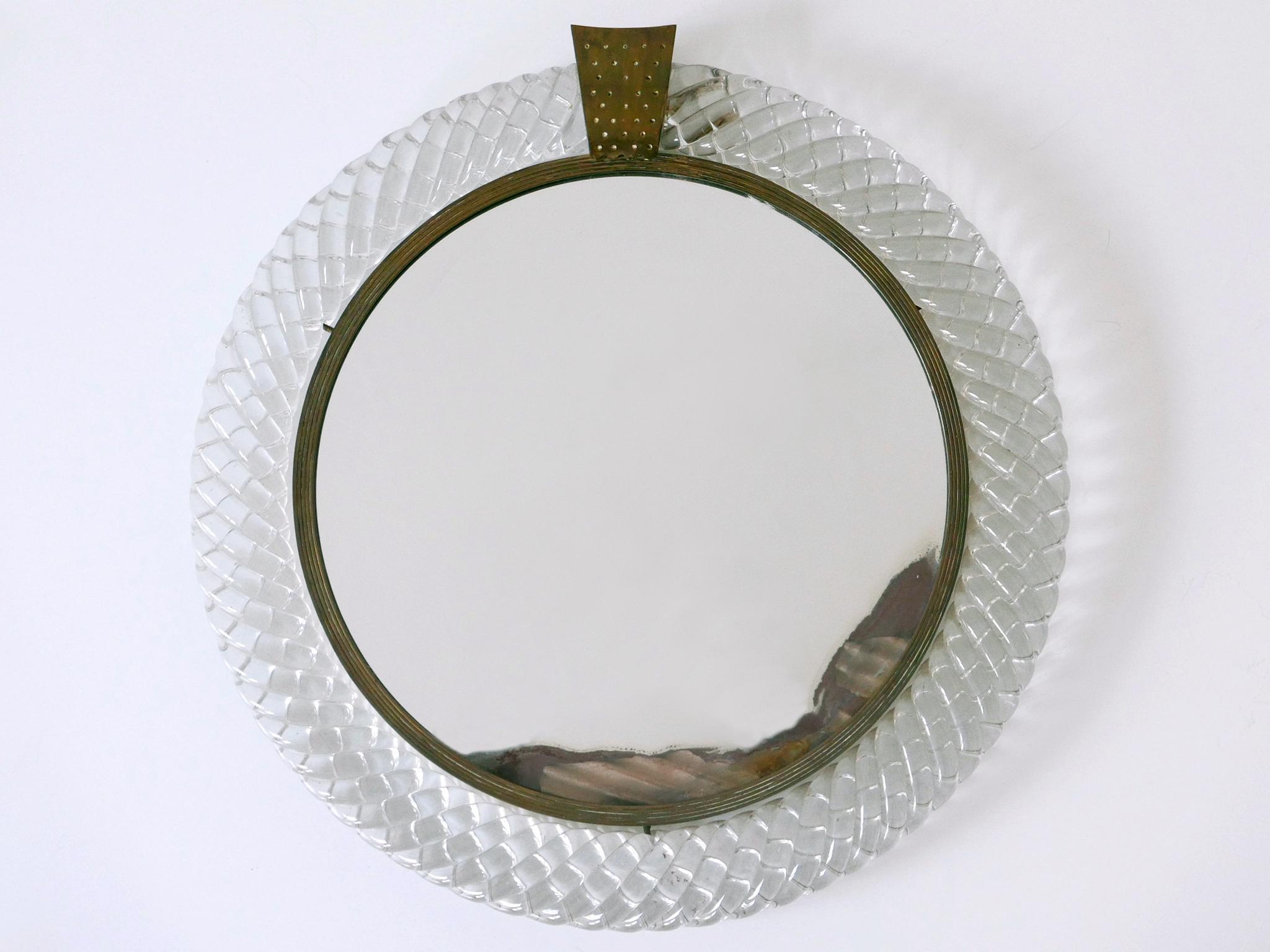 Rare and elegant Mid Century Modern Murano Glass treccia frame wall mirror. Designed by Carlo Scarpa for Venini, Italy, 1950s.

Executed in Murano Glass, mirror glass, brass and plywood.

Measurements:
Overall diameter: 15.36 in. (39 cm)
Height: