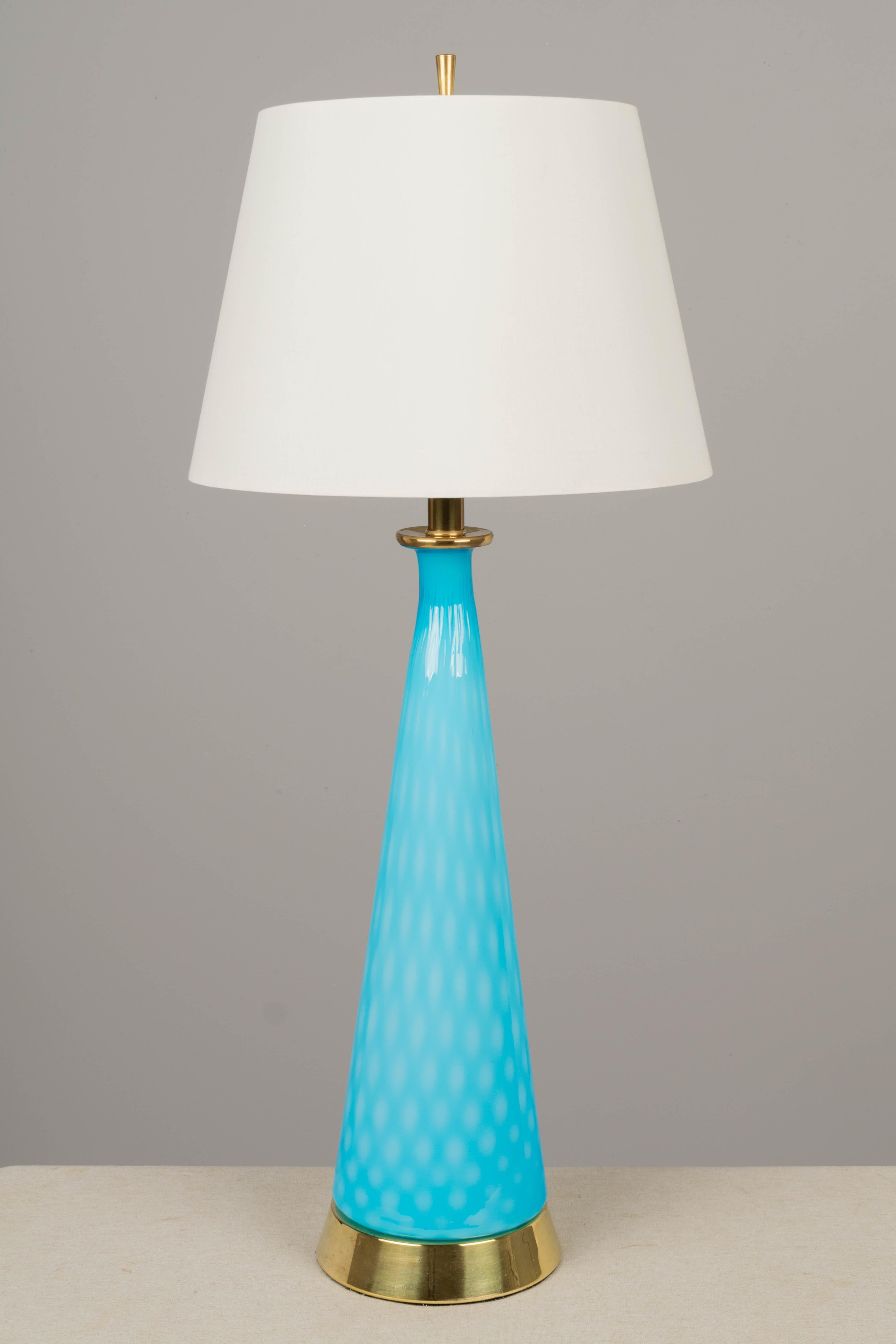 A Midcentury Modern Murano glass lamp with tall bottle form cased glass in bright aqua blue color. Original brass plated base. Rewired with new socket and cord. Shade is NOT included. Circa 1950-1970
Overall dimensions with the shade: 33.25