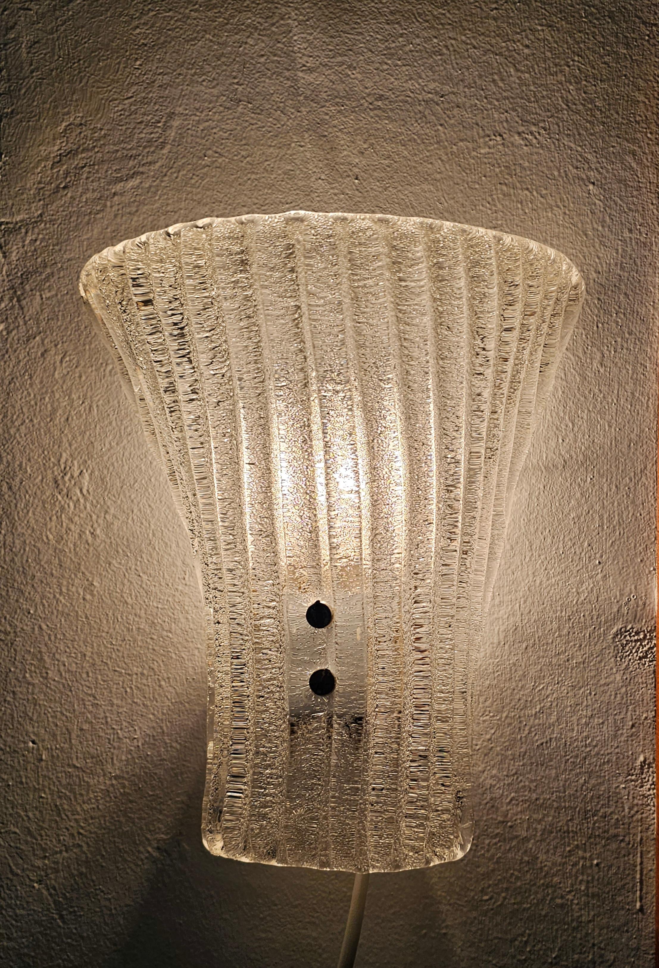In this listing you will find a pair of rare Mid Century Modern Murano Glass Sconces designed by Barovier and Toso. They feature frosty, textured glass shades, curved towards the top. Each sconces requires a single E14 light bulb, available