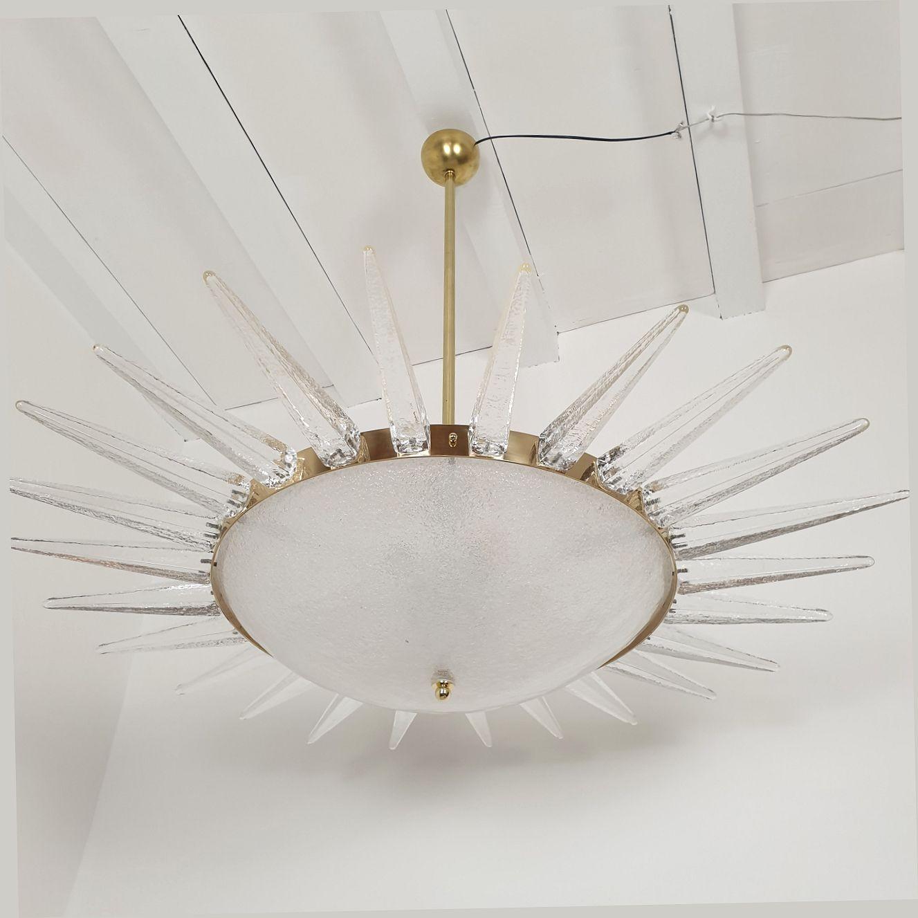 Mid Century Modern large Murano glass chandelier, attributed to Seguso, Italy 1970.
The chandelier is made of clear Murano glass: top and bottom central glasses are textured and translucent.
And it's surrounded with a Murano 