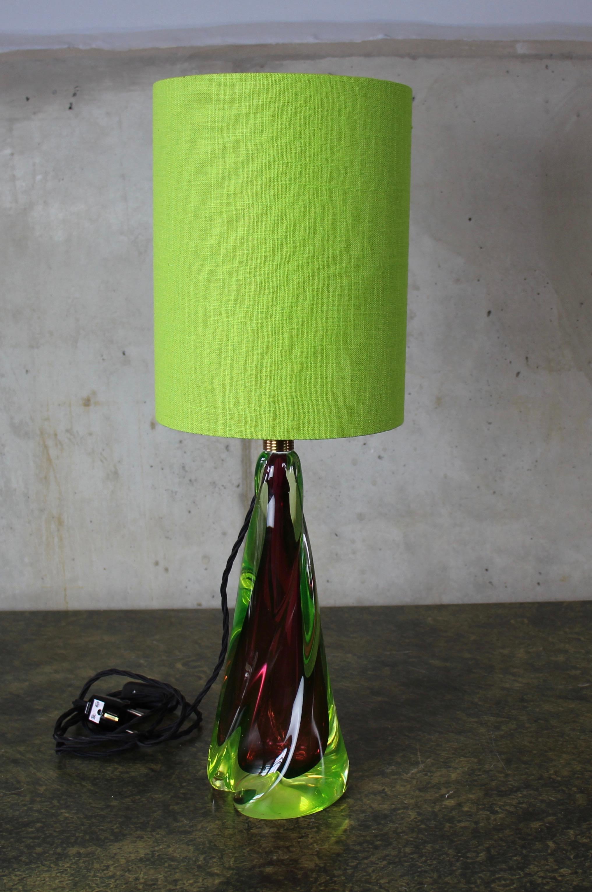 This Murano lamp from the 1950s captivates with its bright and cheerful colors. The core is in a burgundy, the outer layer in a green / yellow, much like uranium glass. The lampshade is handmade and has been redone. The fabric has a rough linen