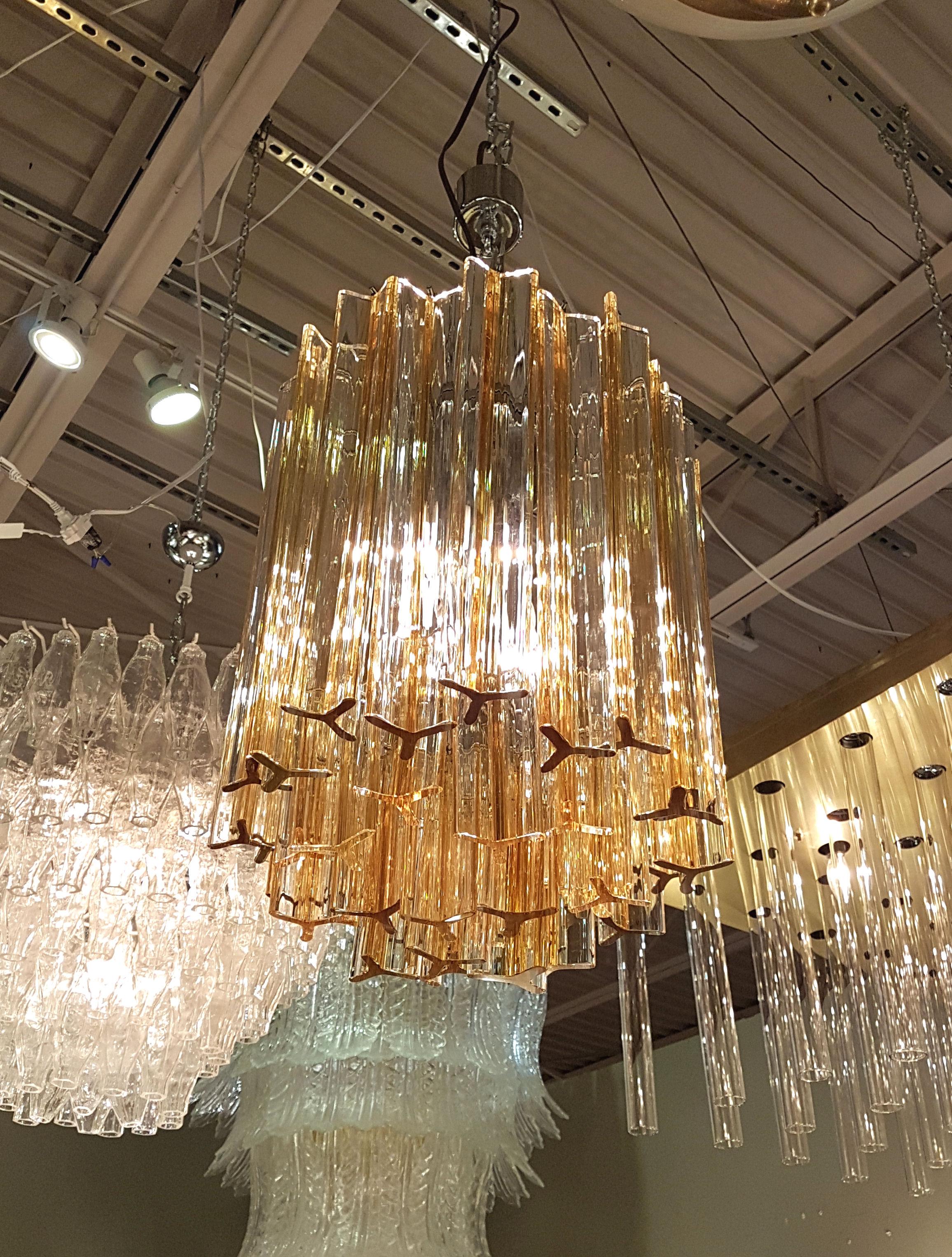 Mid-Century Modern Triedri glass chandelier, by Venini, Italy, circa 1970s.
Transparent Murano glass triedri with Amber color lines.
Frame in chrome, rewired for US.
Beautiful quality and transparency of the Murano glass.
Has a chrome chain and