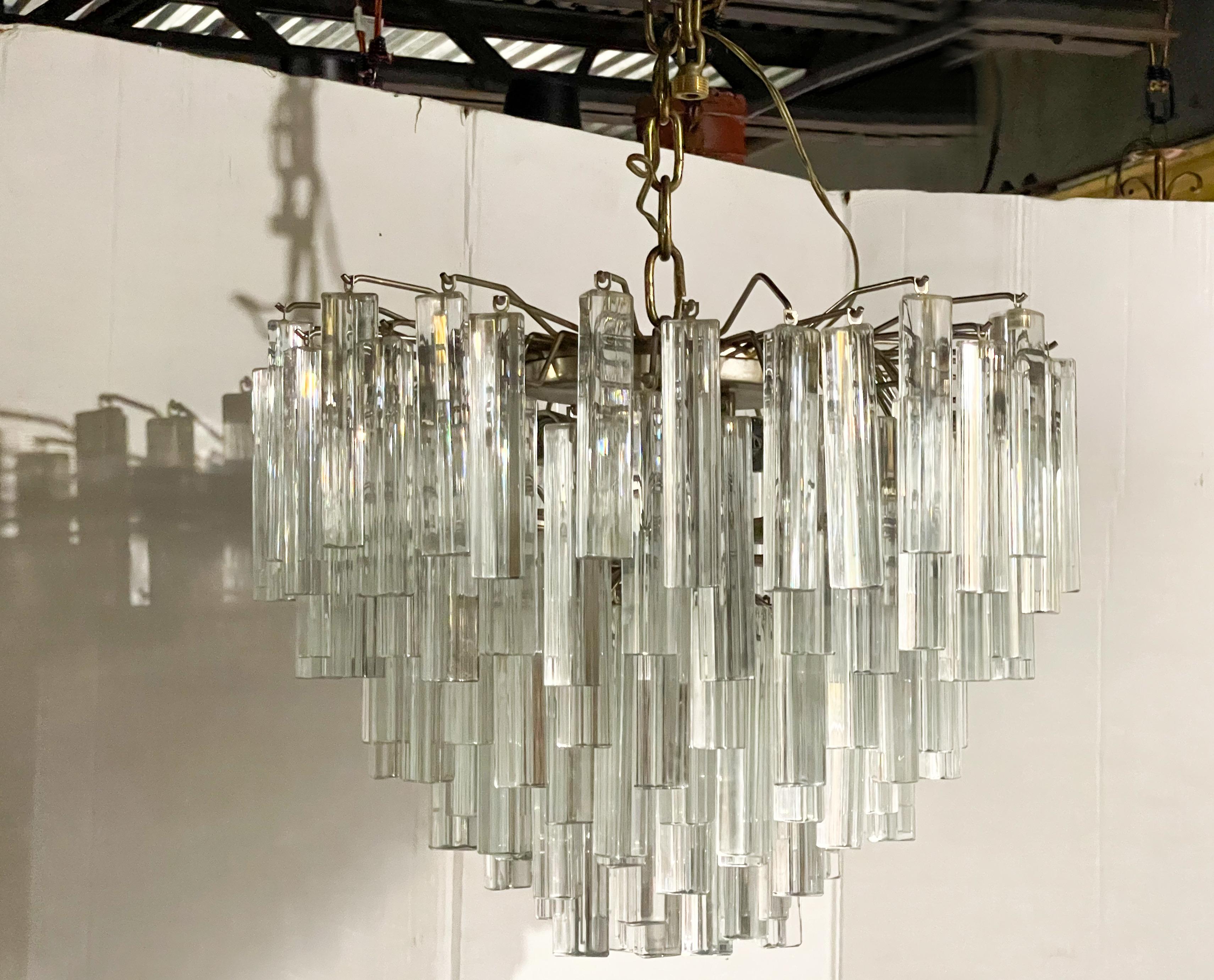 This is a 1960s Murano glass multi-tiered chandelier by Venini with the Tilobo design. The clear prisms hang on a nickel frame. It is in working order. Crystals are six inches in length.