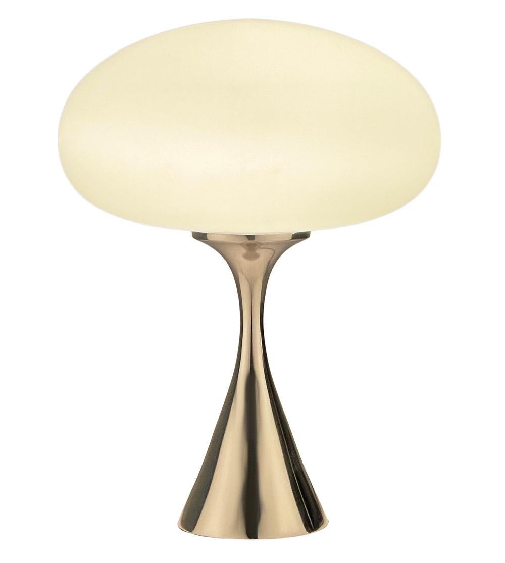 A handsome table lamp in a conical mushroom form after Laurel Lamp Company. The lamp features a chrome plated cast aluminum base and a mouth blown frosted glass lamp shade.