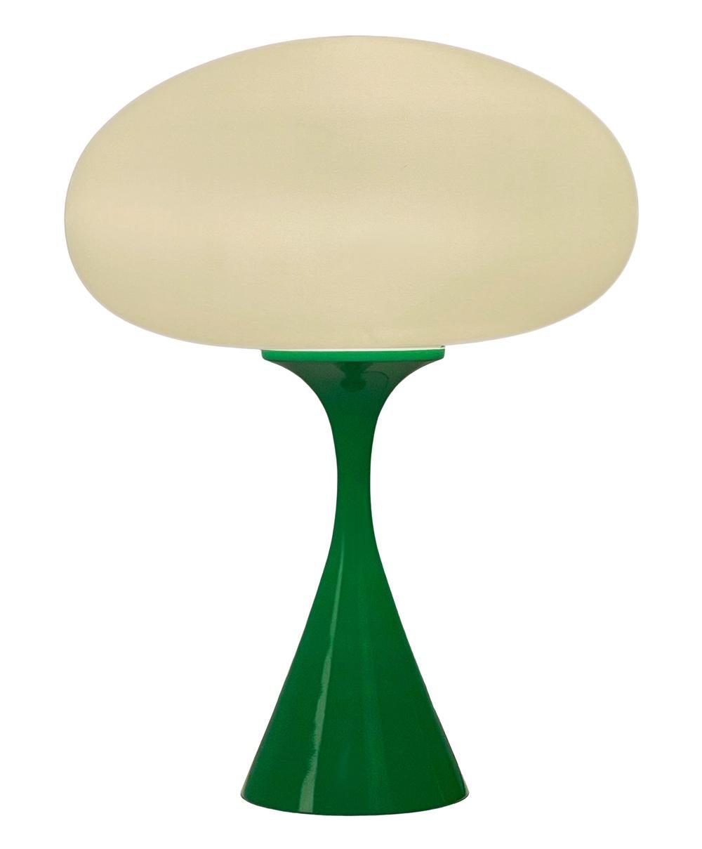 A handsome table lamp in a conical mushroom form after Laurel Lamp Company. The lamp features a cast aluminum base with a green powder coat and a mouth blown frosted glass lamp shade.