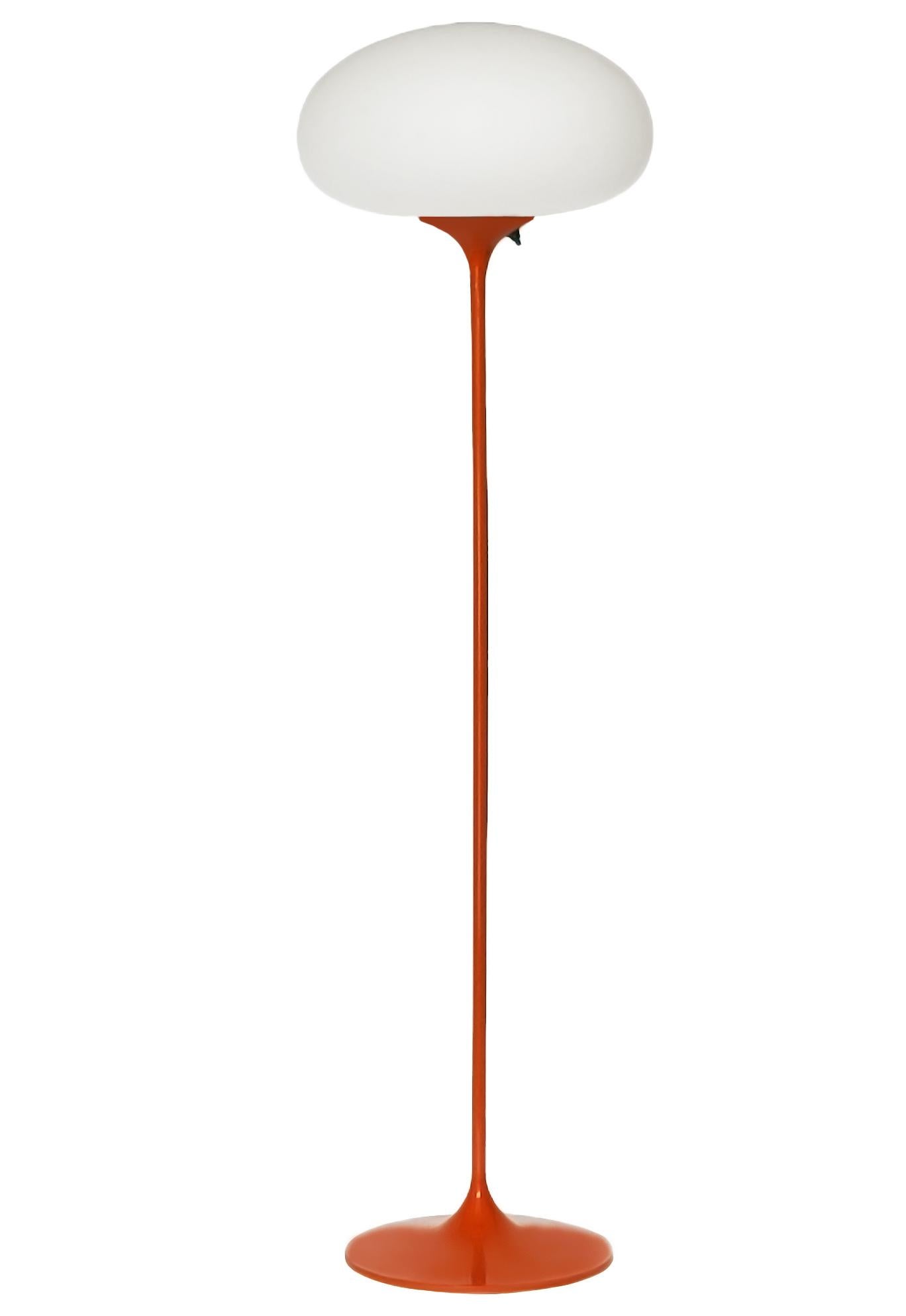 A sleek low profile floor made by Design-Line. It features a cast aluminum main base in a sculptural tulip form. The based is finished in a durable retro orange powder coat. The frosted glass lamp is hand blown and gives off a soft warm filtered