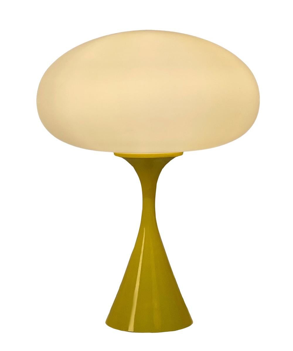 A handsome table lamp in a conical mushroom form after Laurel lamp Company. The lamp features a cast aluminum base with a yellow powder coat and a mouth blown frosted glass lamp shade.