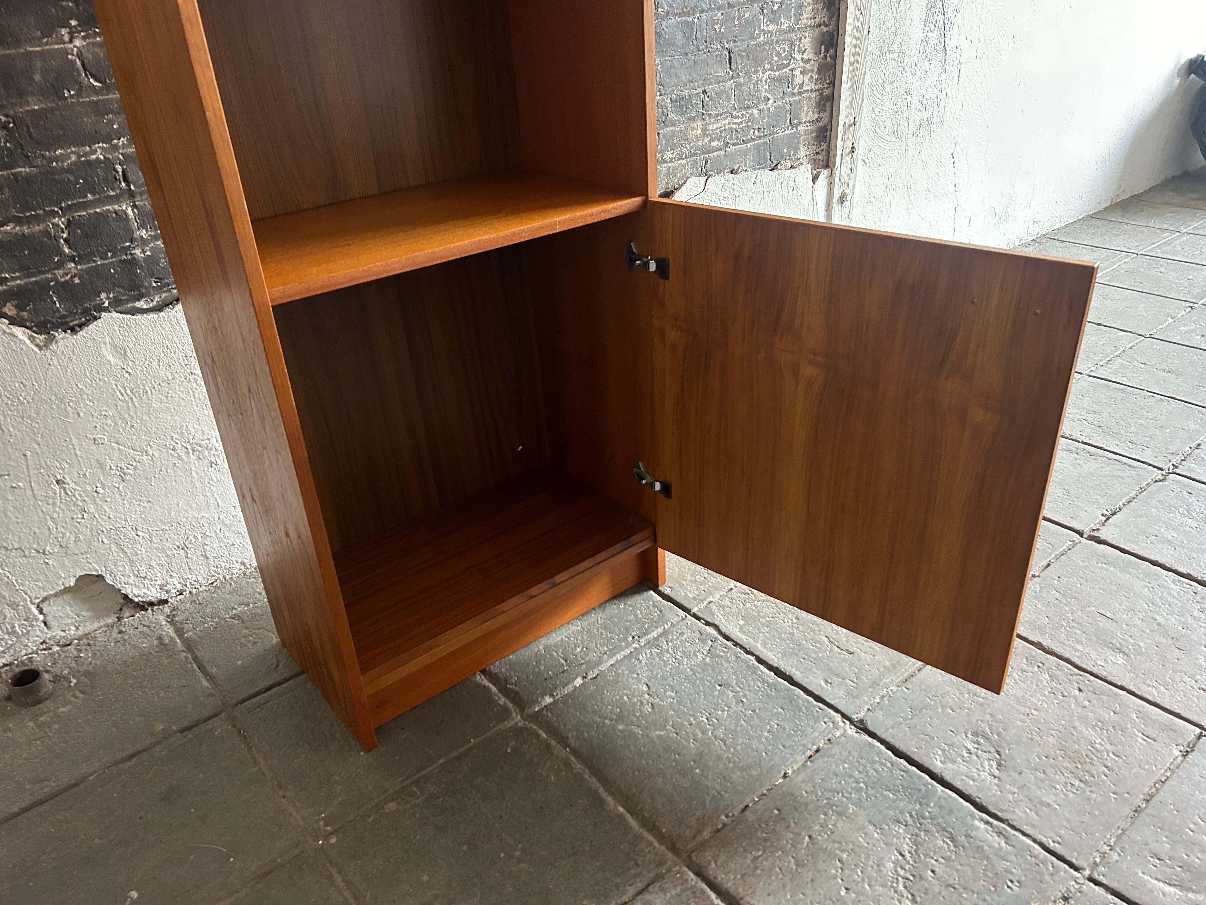 Mid-Century Modern narrow teak tall bookcase with cabinet door Made in Denmark  In Good Condition For Sale In BROOKLYN, NY
