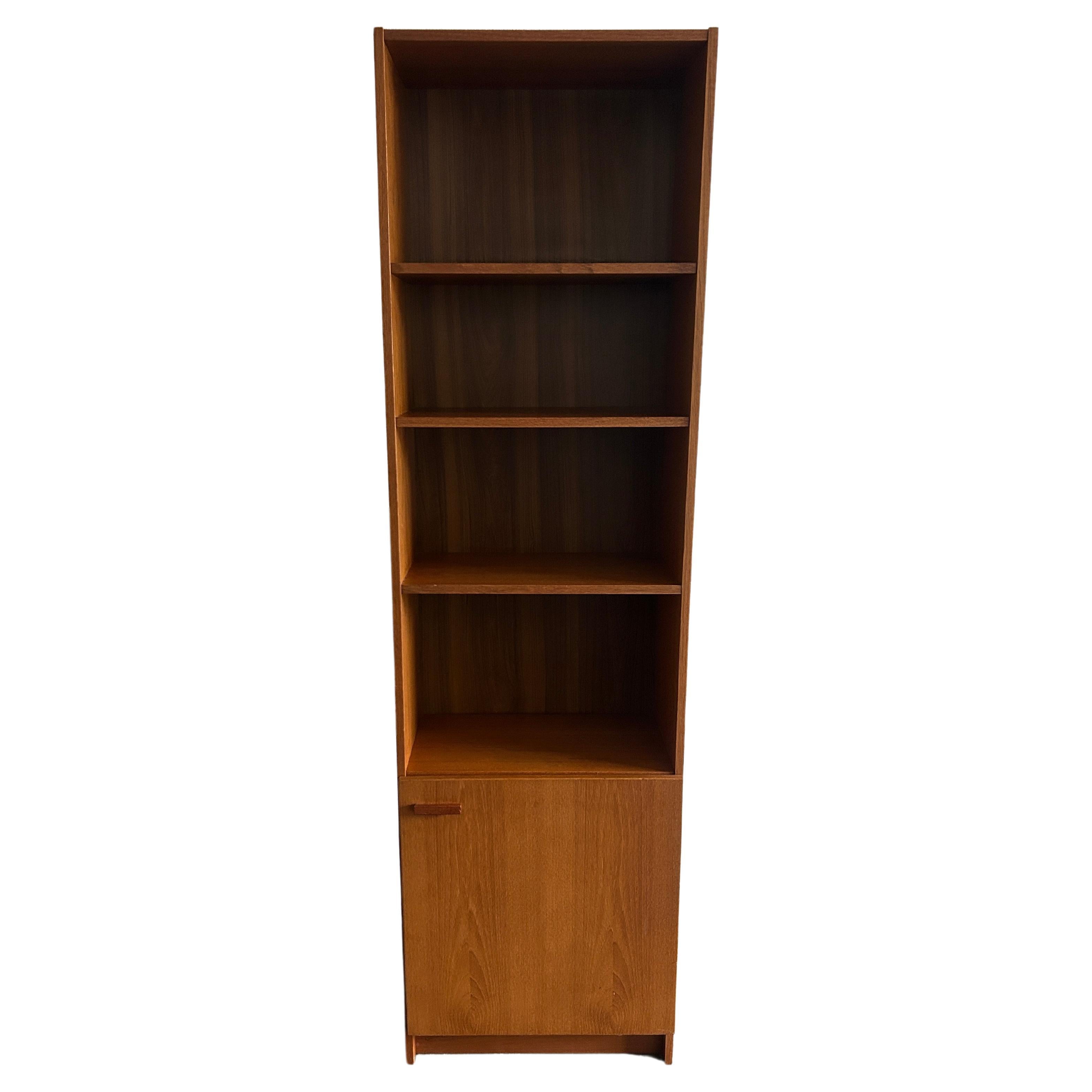 Mid-Century Modern narrow teak tall bookcase with cabinet door Made in Denmark  For Sale