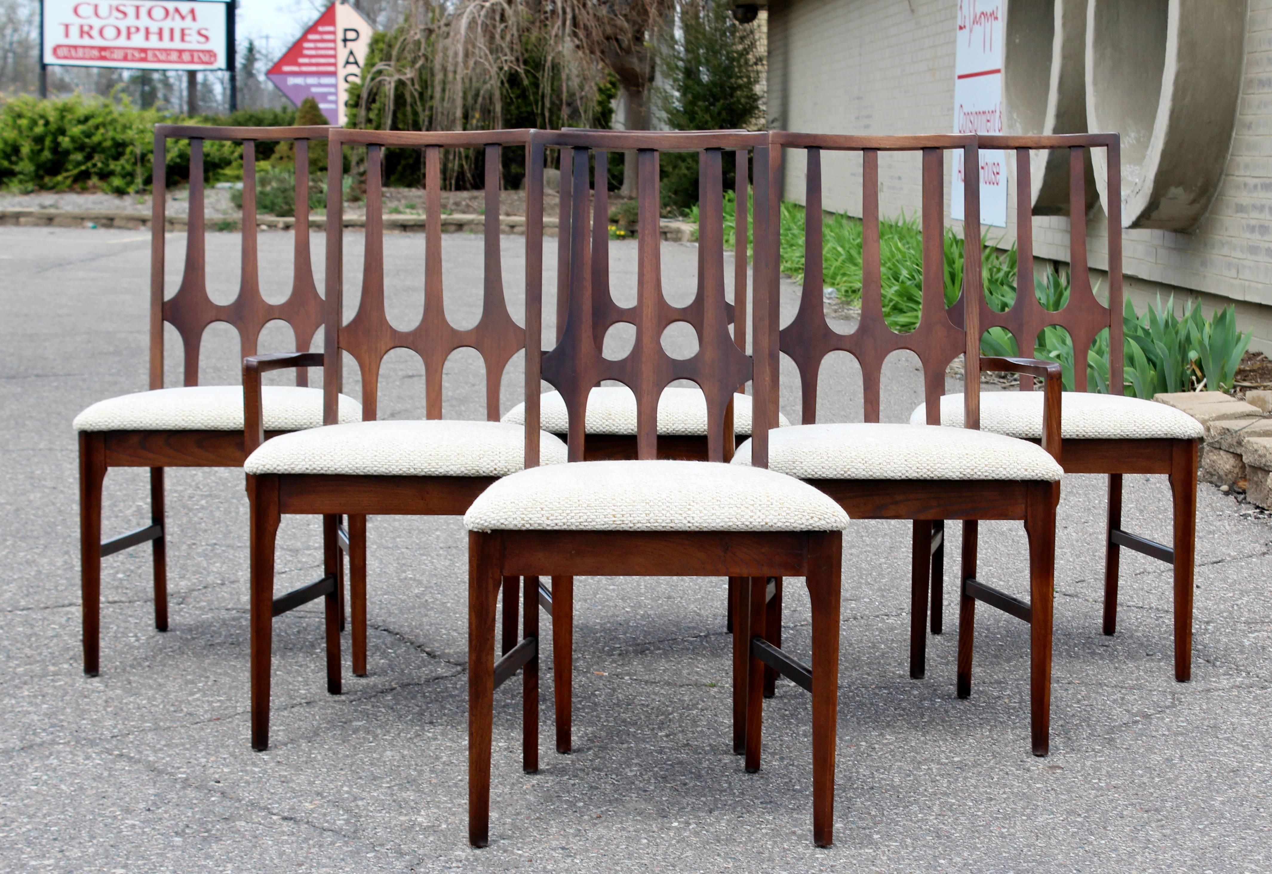For your consideration is gorgeous walnut wood set of six dining chairs, four side and two with arms, by Oscar Neimeyer for Broyhill Brasilia, circa the 1960s. In excellent condition. Just came back from being professionally reupholstered. The