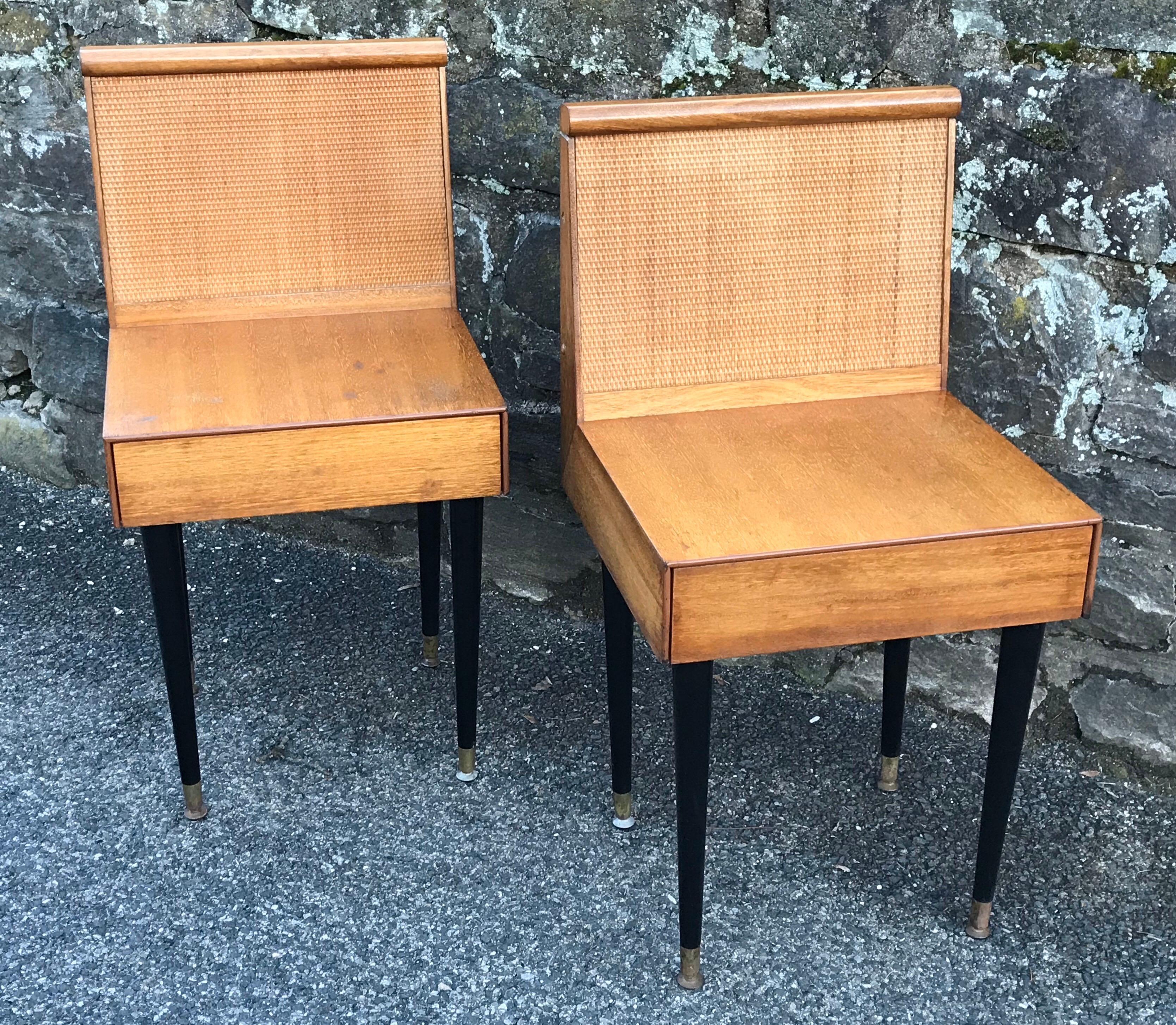 Rare pair of petite and refined nightstands designed by John Keal for Brown Saltman, circa 1950. Constructed of bleached mahogany with caned back panel and one drawer. The nightstands obtain their original black lacquer finish tapered legs and brass