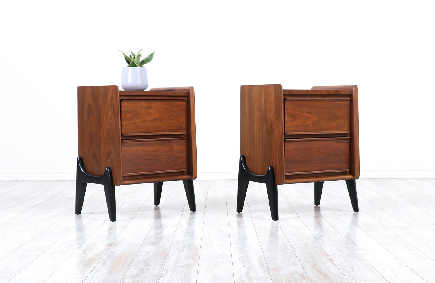 Mid-Century Modern night stands with sculpted bases.