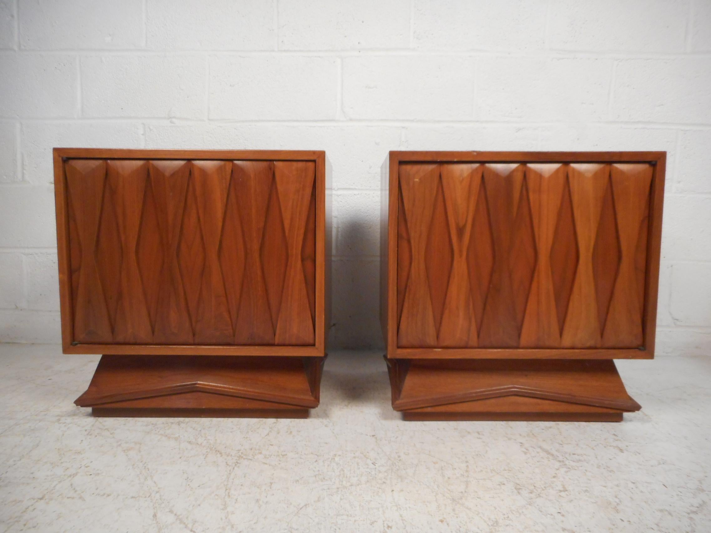Nice pair of Mid-Century Modern nightstands. Eye-catching bowtie accents cover the front of the cabinet doors. Adjustable shelves on the interiors. This pair is sure to be a great addition to any modern interior. Please confirm item location with