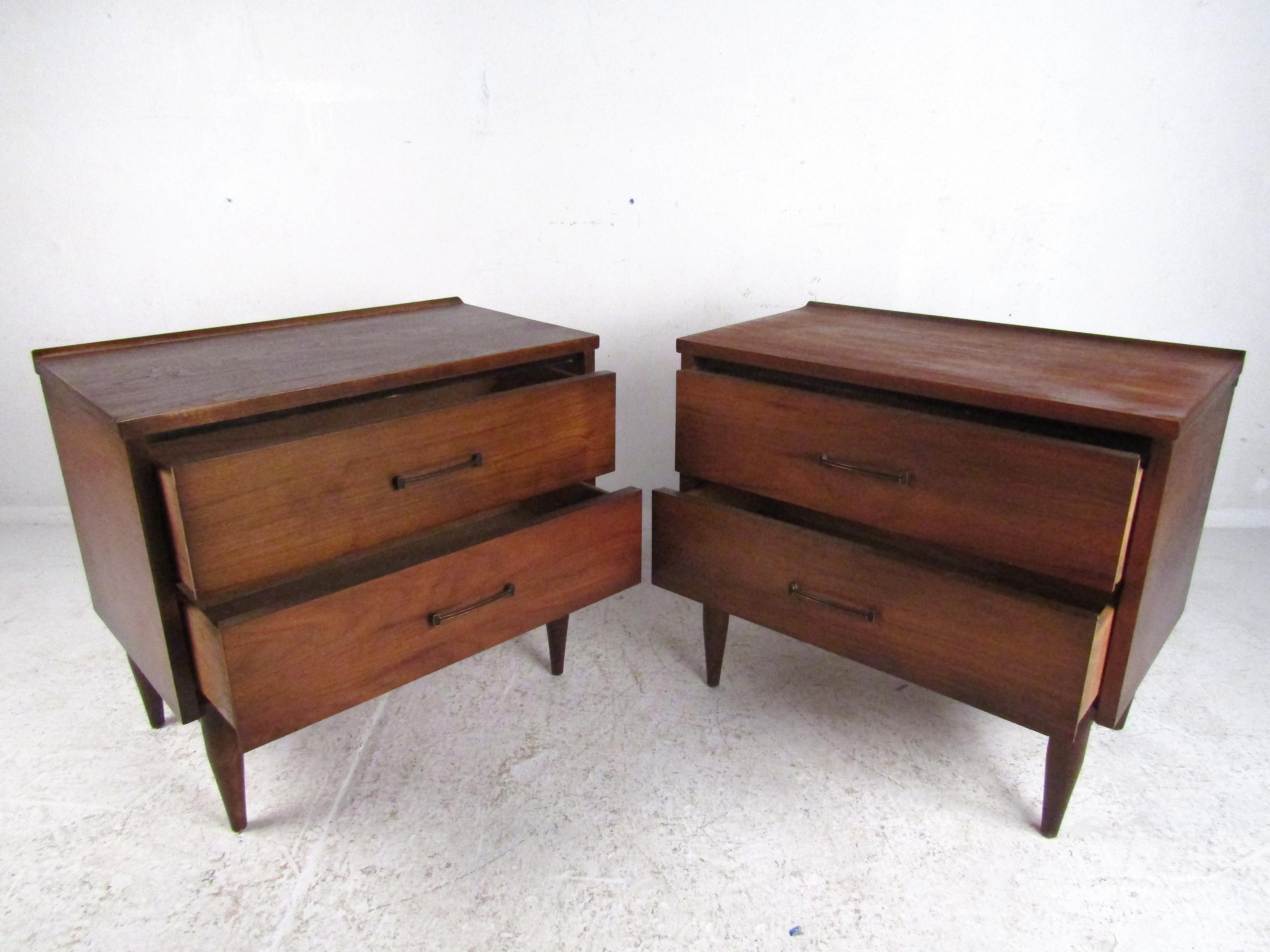 Stunning pair Mid-Century Modern nightstands. Handsome walnut veneer exterior with tapered legs and brass drawer pulls. Nice addition to any modern interior. Please confirm item location with dealer (NJ or NY).