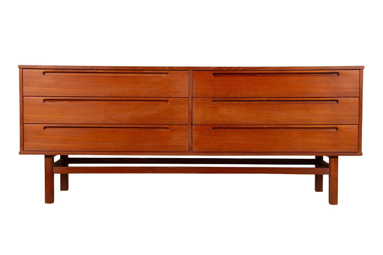 Beautiful Danish modern teak long dresser designed by Nils Jonsson and manufactured by HJN Mobler, made in Denmark circa 1960’s. Features a rectangular top over six (6) easy gliding dovetail drawers with Jonsson’s iconic recessed pulls, hardwood