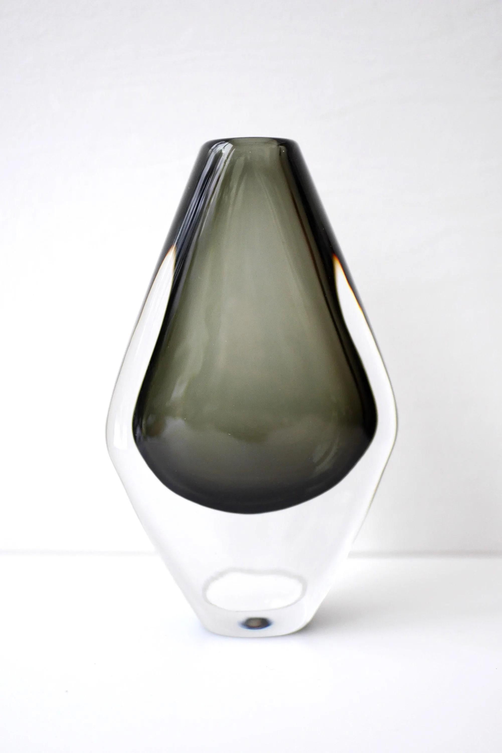 Un bellissimo vaso in vetro sommerso fatto a mano e firmato dal talentuoso Nils Landberg per la vetreria Orrefors, in Svezia, negli anni Sessanta. Questo vaso, di colore grigio scuro/verde e ricoperto di cristallo trasparente, fa parte della serie