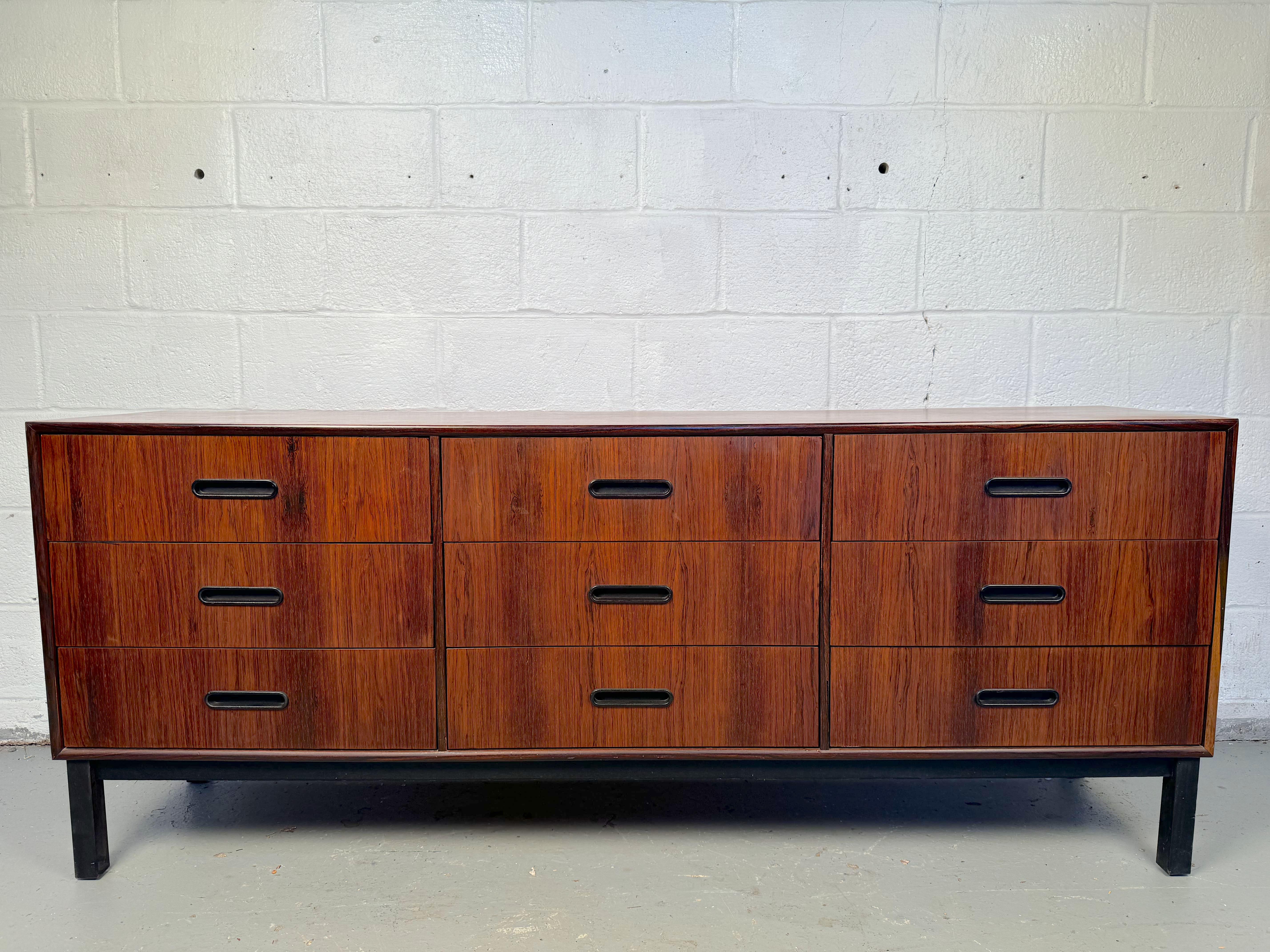 Step into timeless elegance with this exquisite Mid-Century Nine Drawer Rosewood Dresser. Expertly crafted from luxurious rosewood, this piece features a rich, warm finish that showcases the natural grain, adding character and sophistication to any