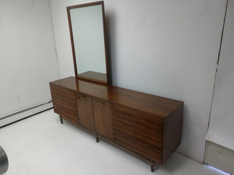 Fabulous and very large, (7 ft) dresser with mirror by Merton Gershun for American of Martinsville furniture. Walnut with oak secondary wood for drawers. Two doors conceal 3 drawers for more storage while on each side is 3 drawers. In very good